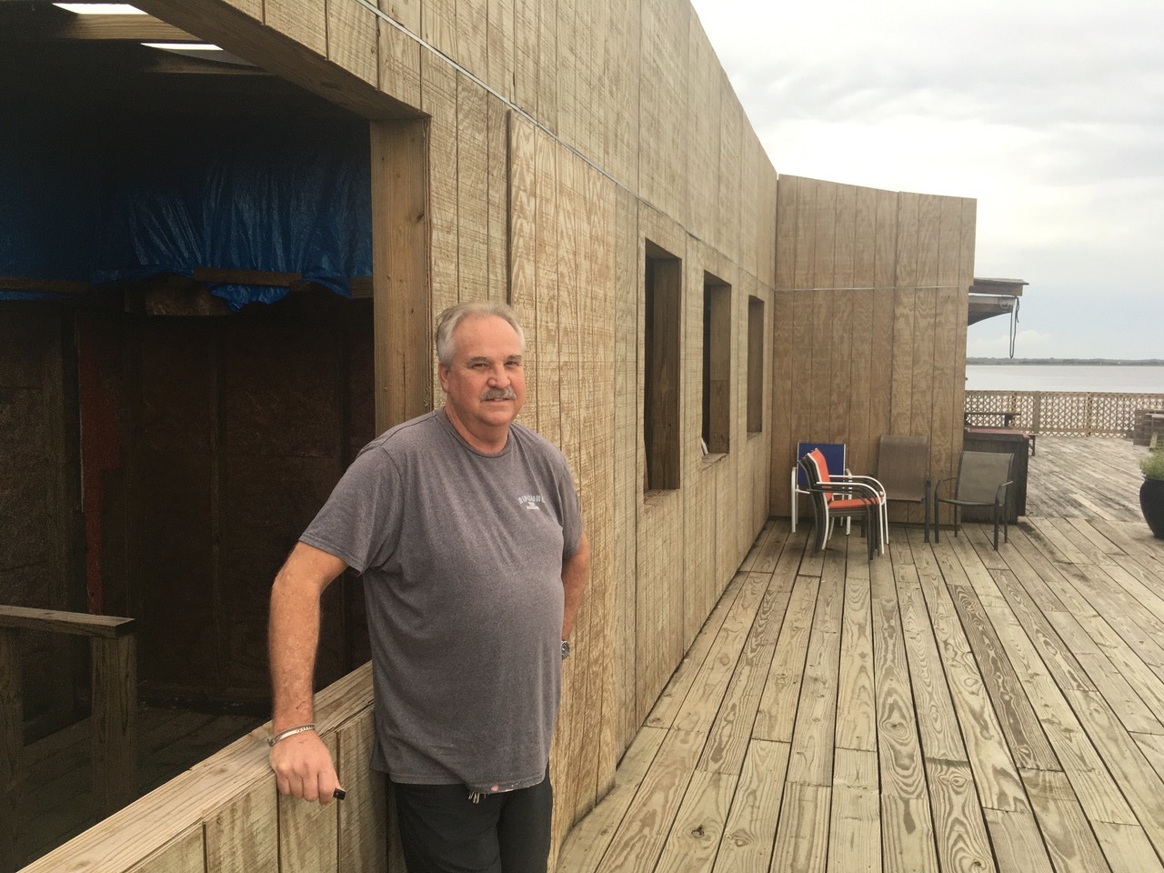 Singleton’s Seafood Shack owner Dean Singleton next to the new wall that separates the deck addition from the restaurant.