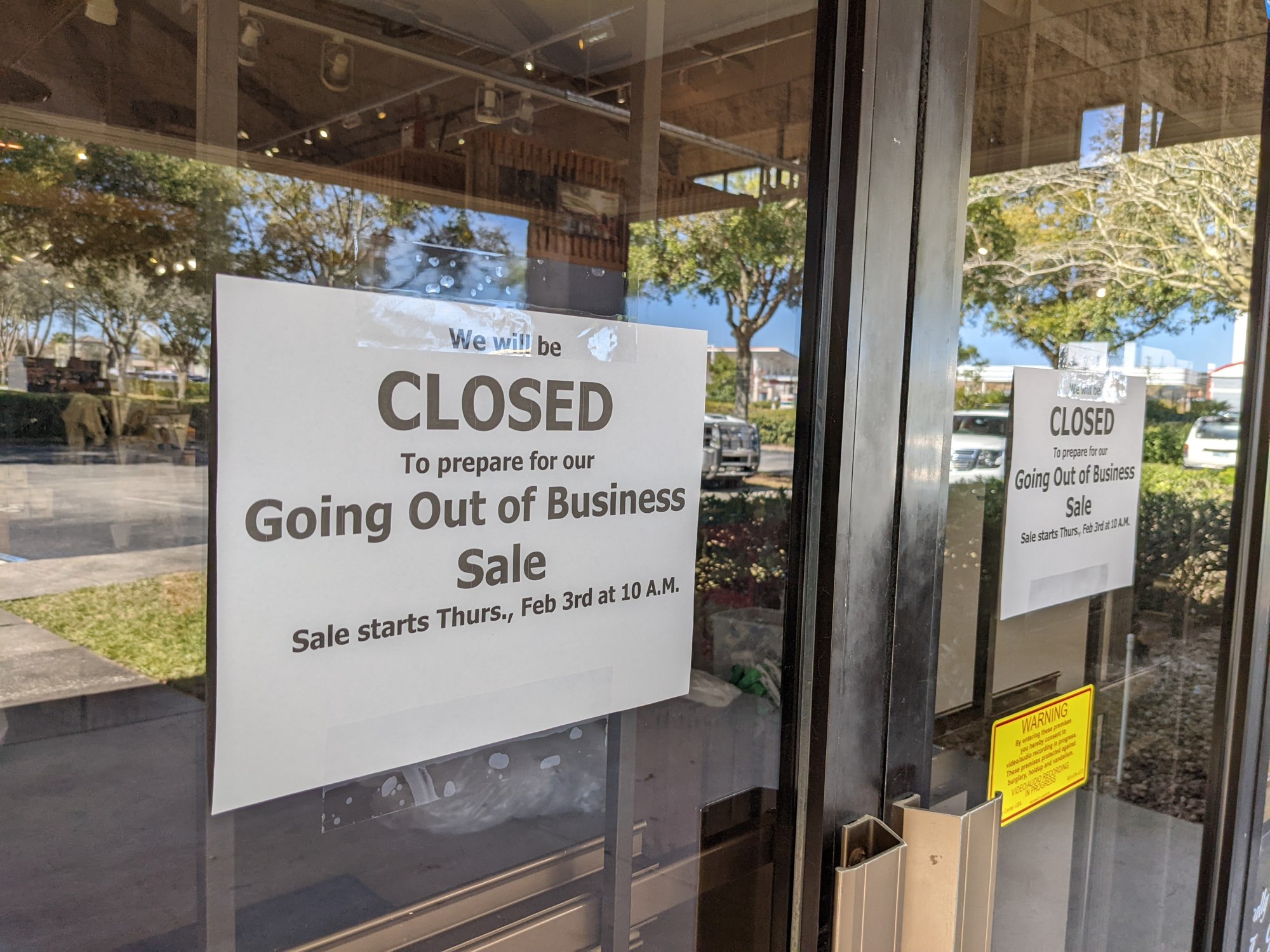 Signs announce the closing on the front door of Black Creek Outfitters.