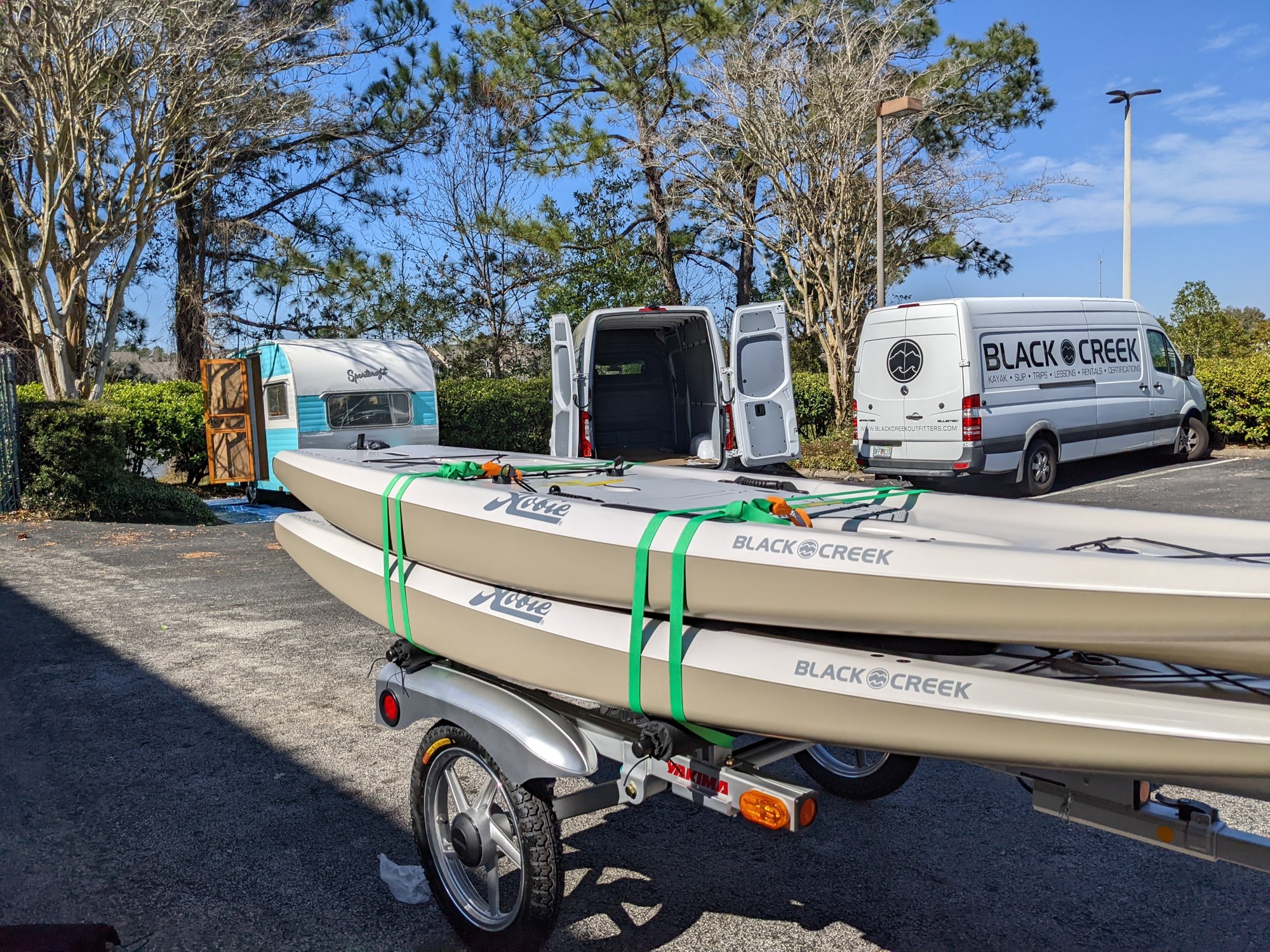 Kayaks and vans in the parking lot to the Black Creek Outfitters store.