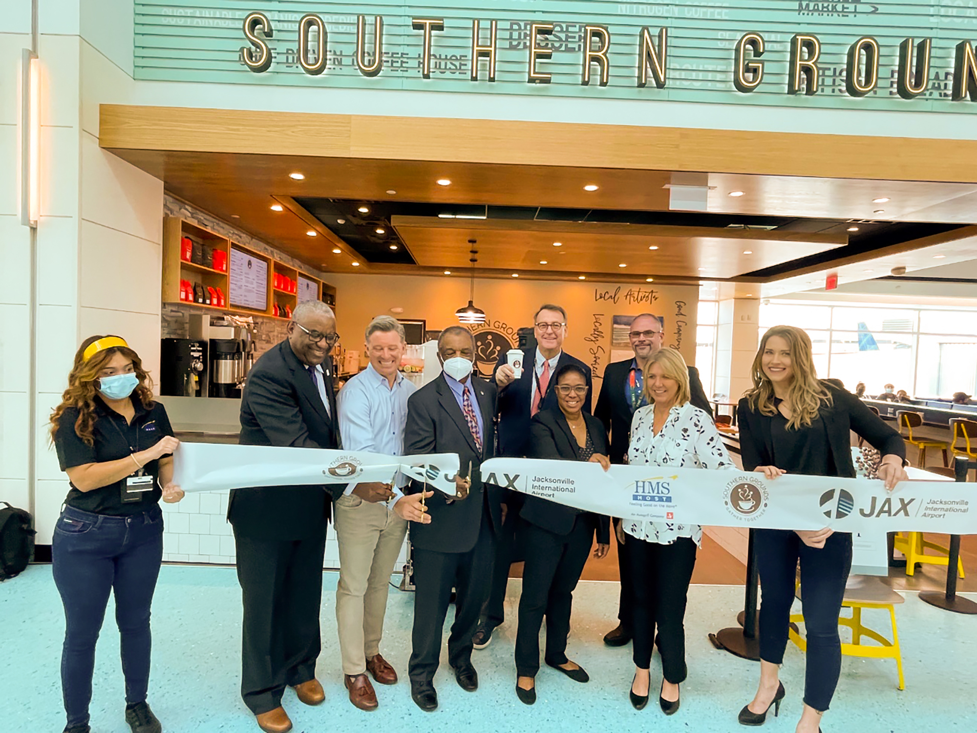 Mark Janasik, owner of Southern Grounds, third from left, cuts the ribbon at his new Jacksonville International Airport shop.