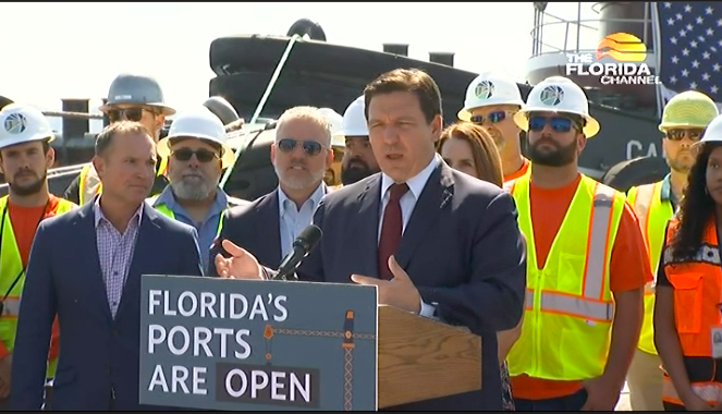 Gov. Ron DeSantis announces the new service while Mayor Lenny Curry, left, and other officials and workers look on.