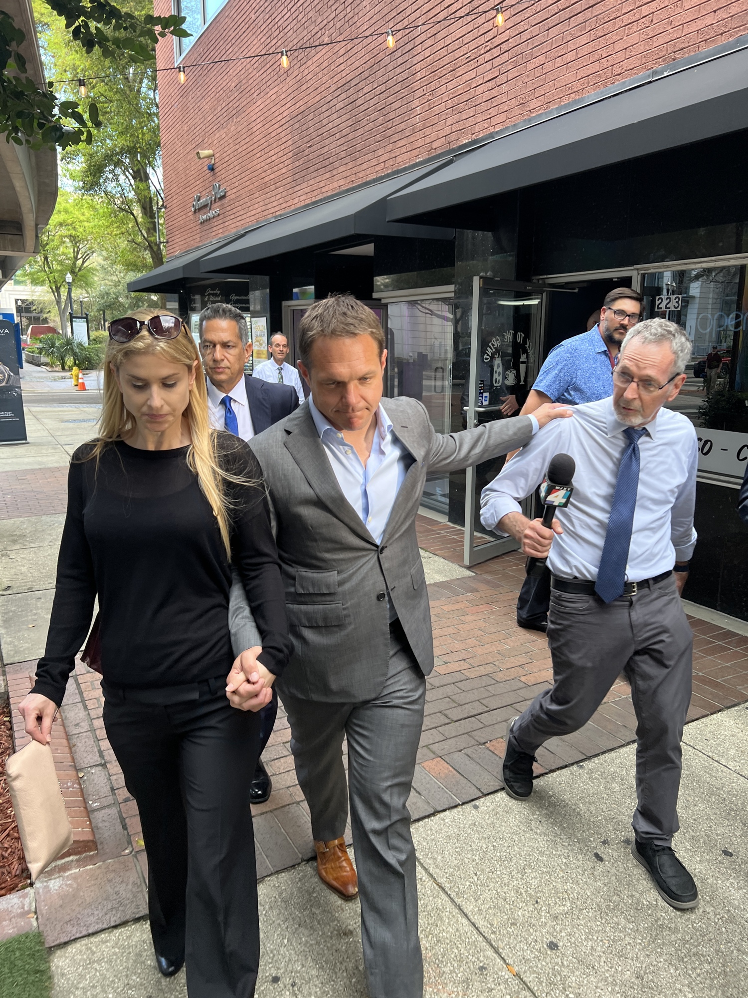 Former JEA CEO Aaron Zahn walks with his wife while being questioned by members of the news media March 8 after leaving the federal courthouse where he pleaded not guilty to federal charges.