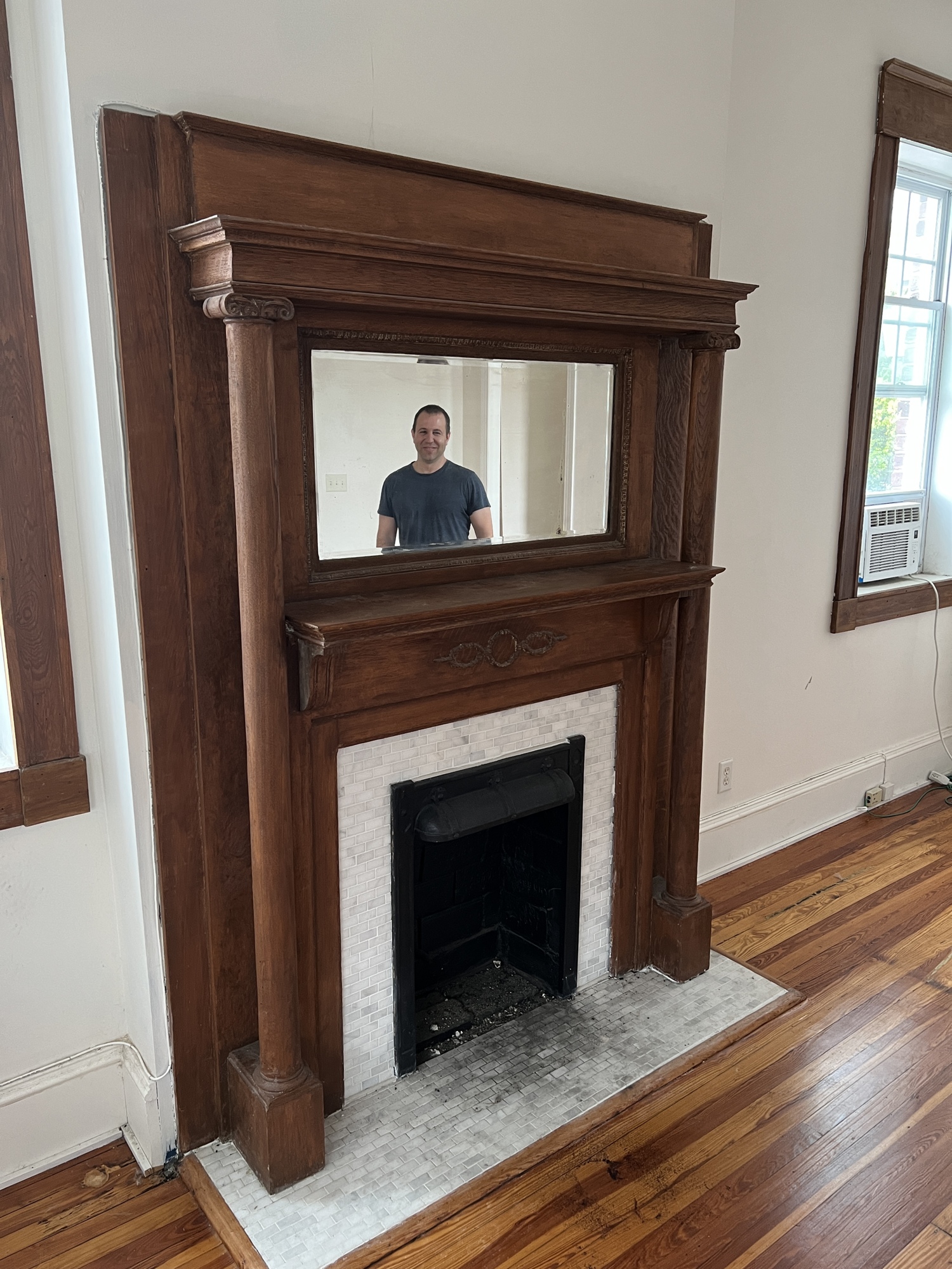 Eric Adler is reflected in the mirror over one of the funeral home's fireplaces.