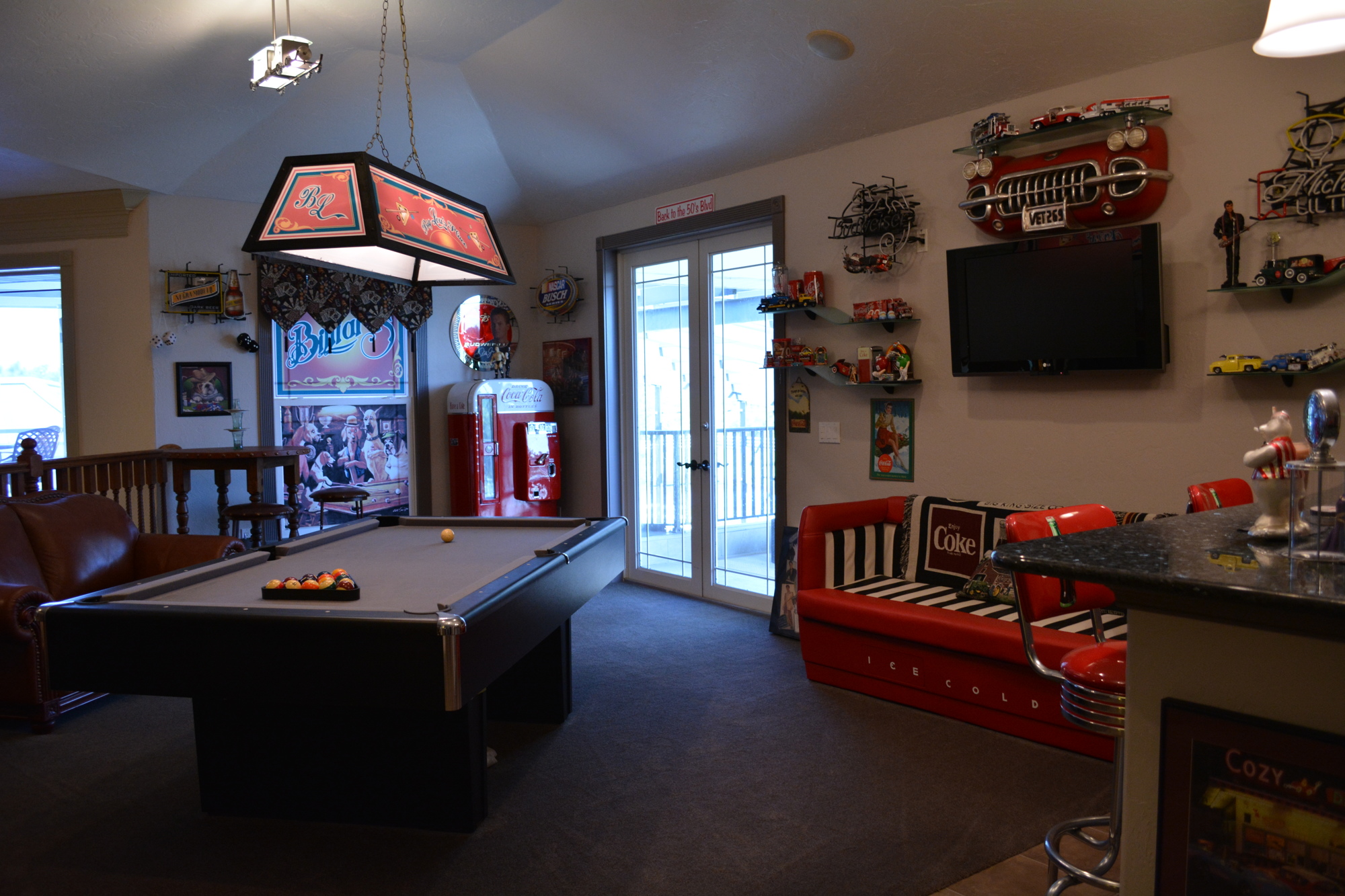 Upstairs in the main home, the owners have created a 1950s themed space to play pool, relax or drink. It sits adjacent to a home theater space.