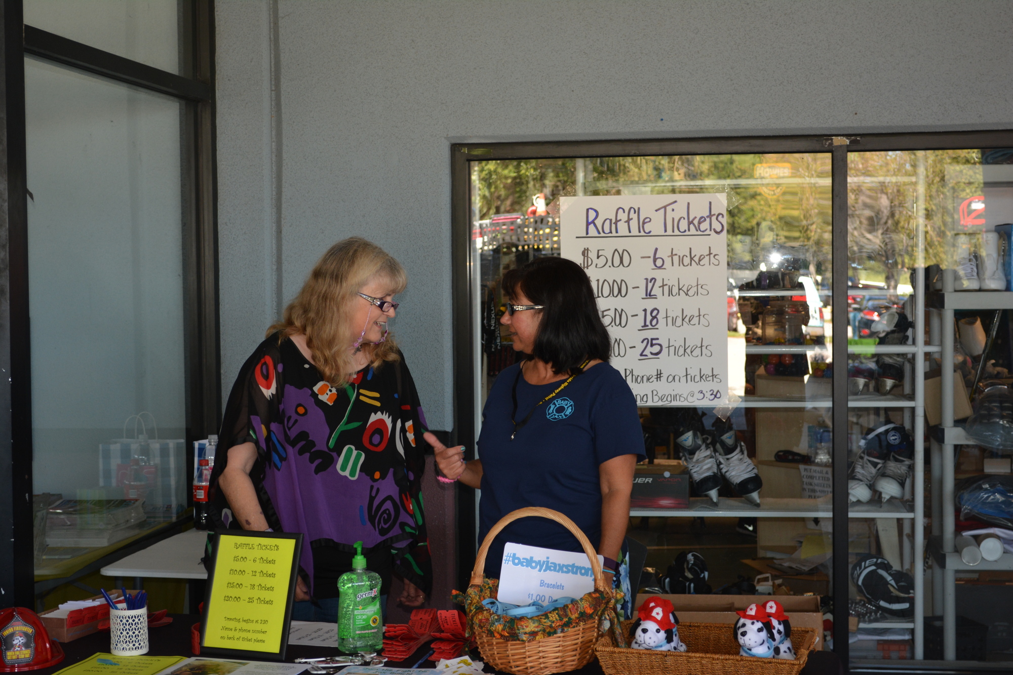 Linda Key, left, and Mary Egan sell raffle tickets to raise money for Baby Jax on Saturday at the Ellenton Ice and Sports Complex.