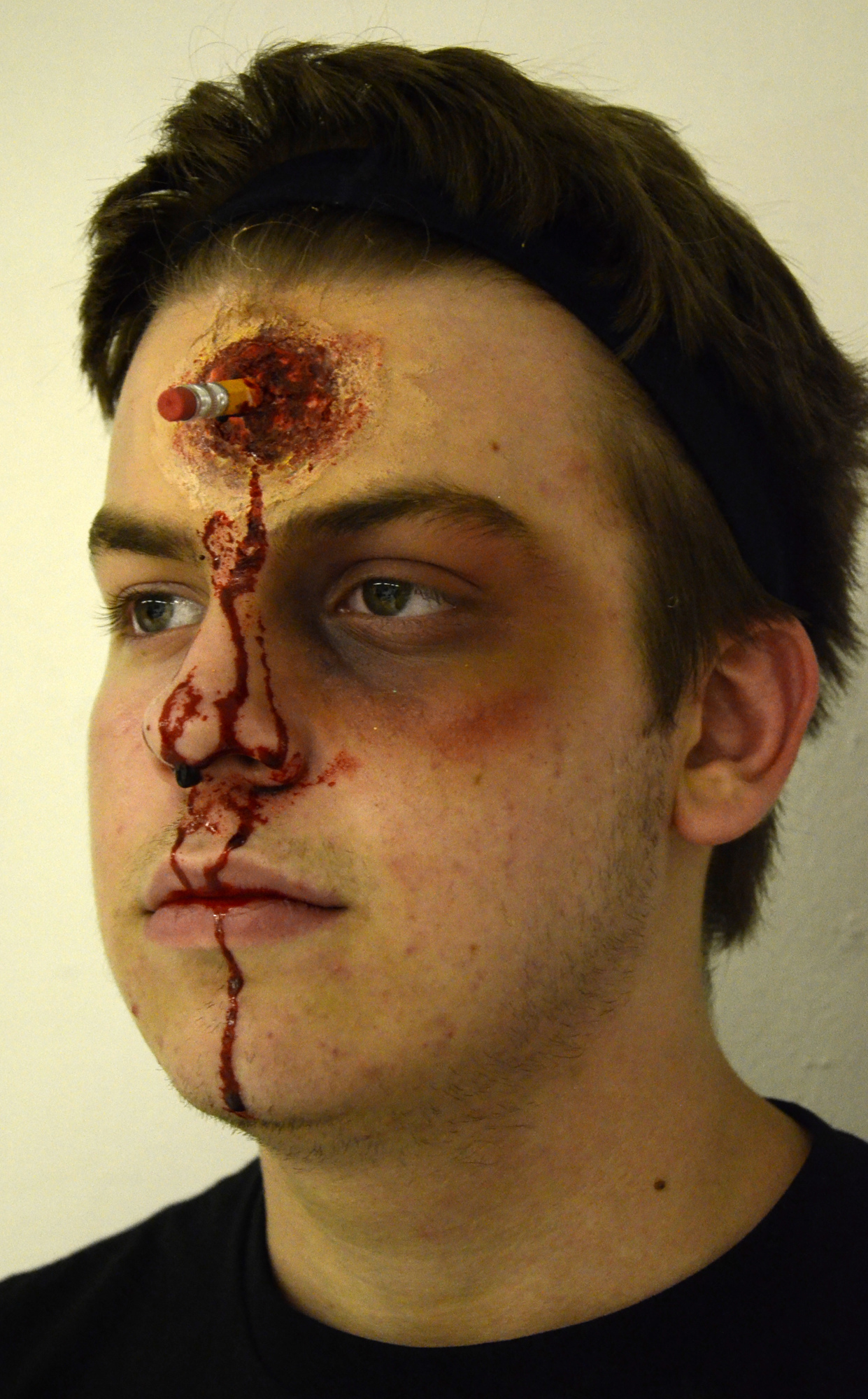 Jackson Helwege's bloody student look is complete after Rachel Knowles, makeup artist, glued a pencil into the original gunshot wound to change the look.