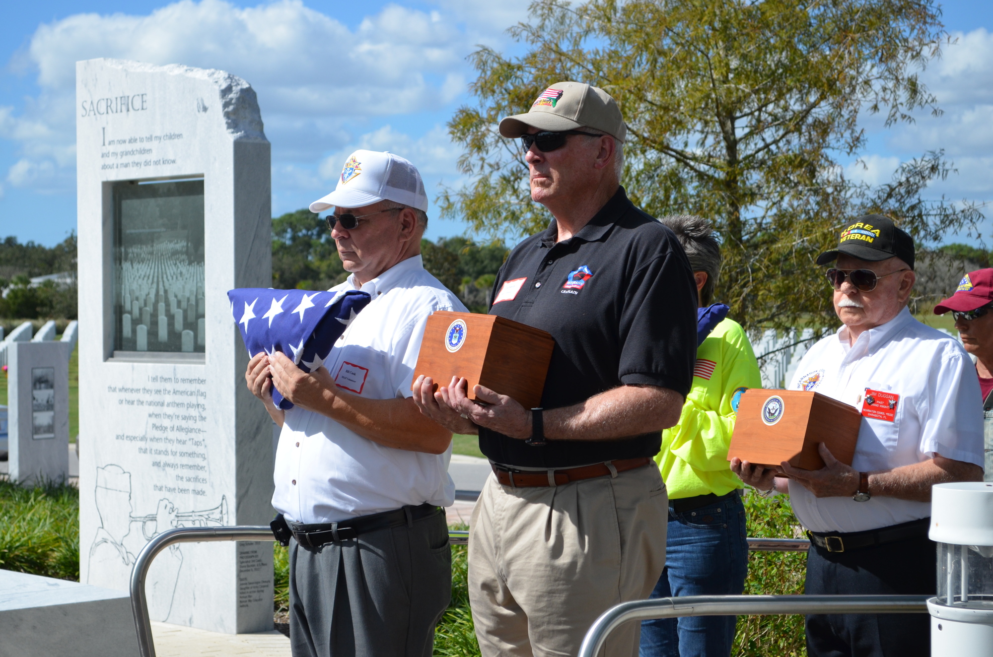Bill Cook and Ted Smith lead the group of volunteers and family members carrying urns.