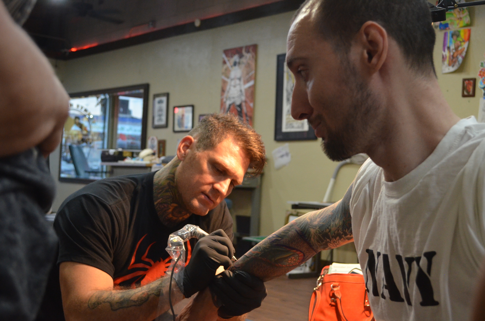 Kyle Dunbar works on a custom sleeve for Navy veteran James Duffy.