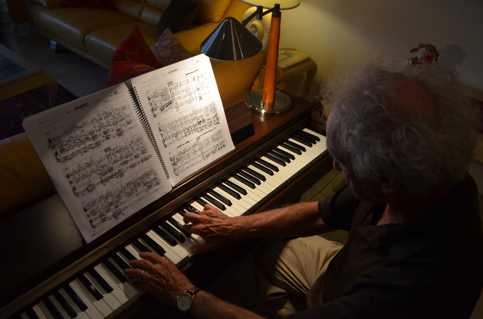Jerry Bilik spends hours writing and arranging scores at his keyboard piano in his living room in Pelican Cove.