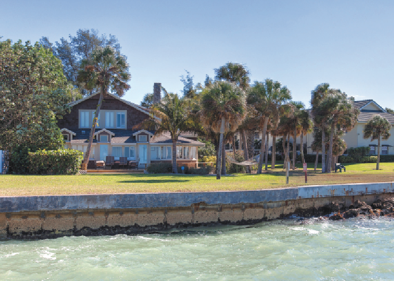 The Siesta Key home has a Gulf-front deck with a seawall and fishing pier.