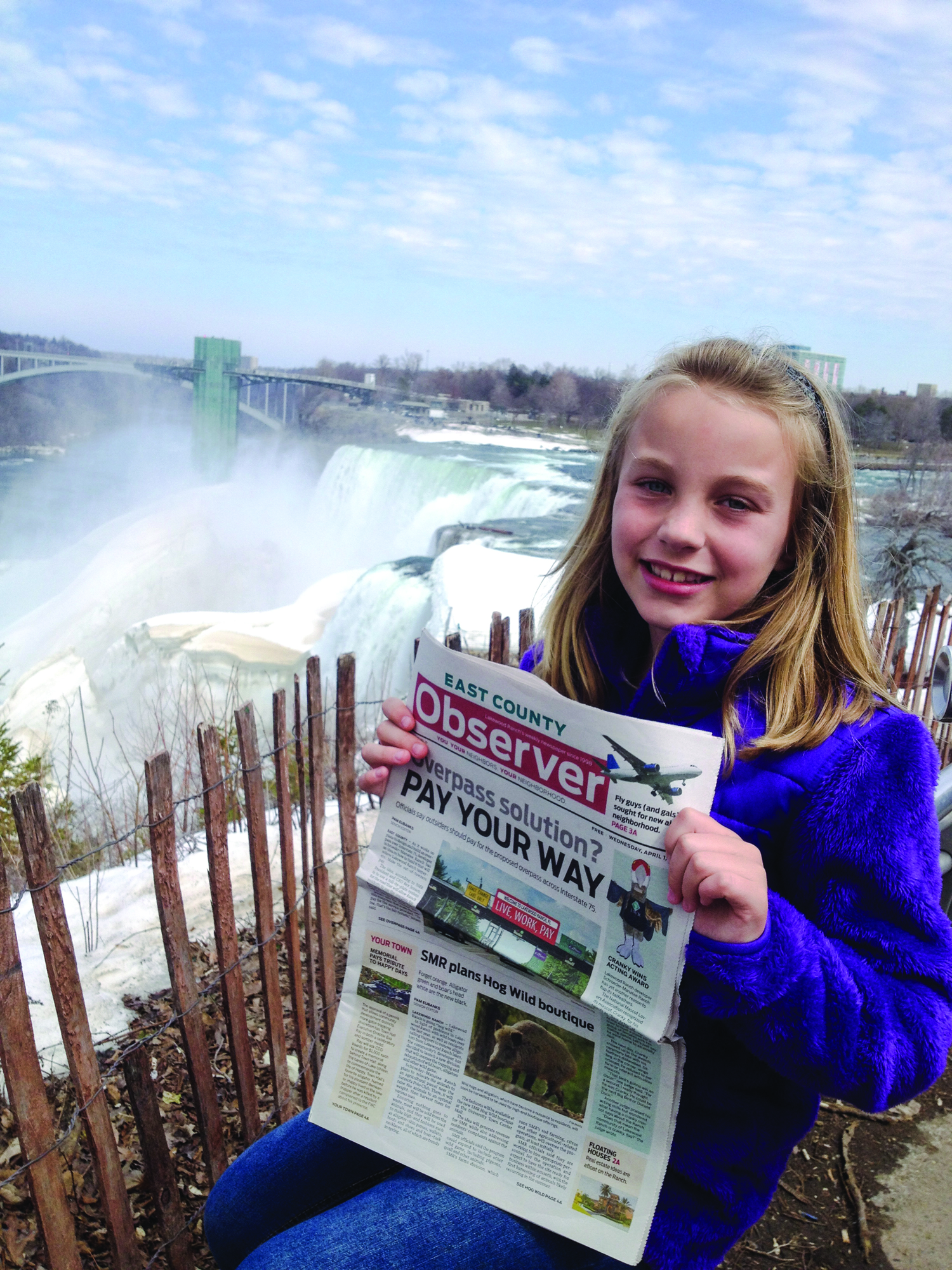 Ava Banks enjoys her April Fools’ Day edition of the East County Observer while marveling at Niagara Falls in New York. Ava visited the New York area over spring break to celebrate her grandparents’ 70th wedding anniversary.