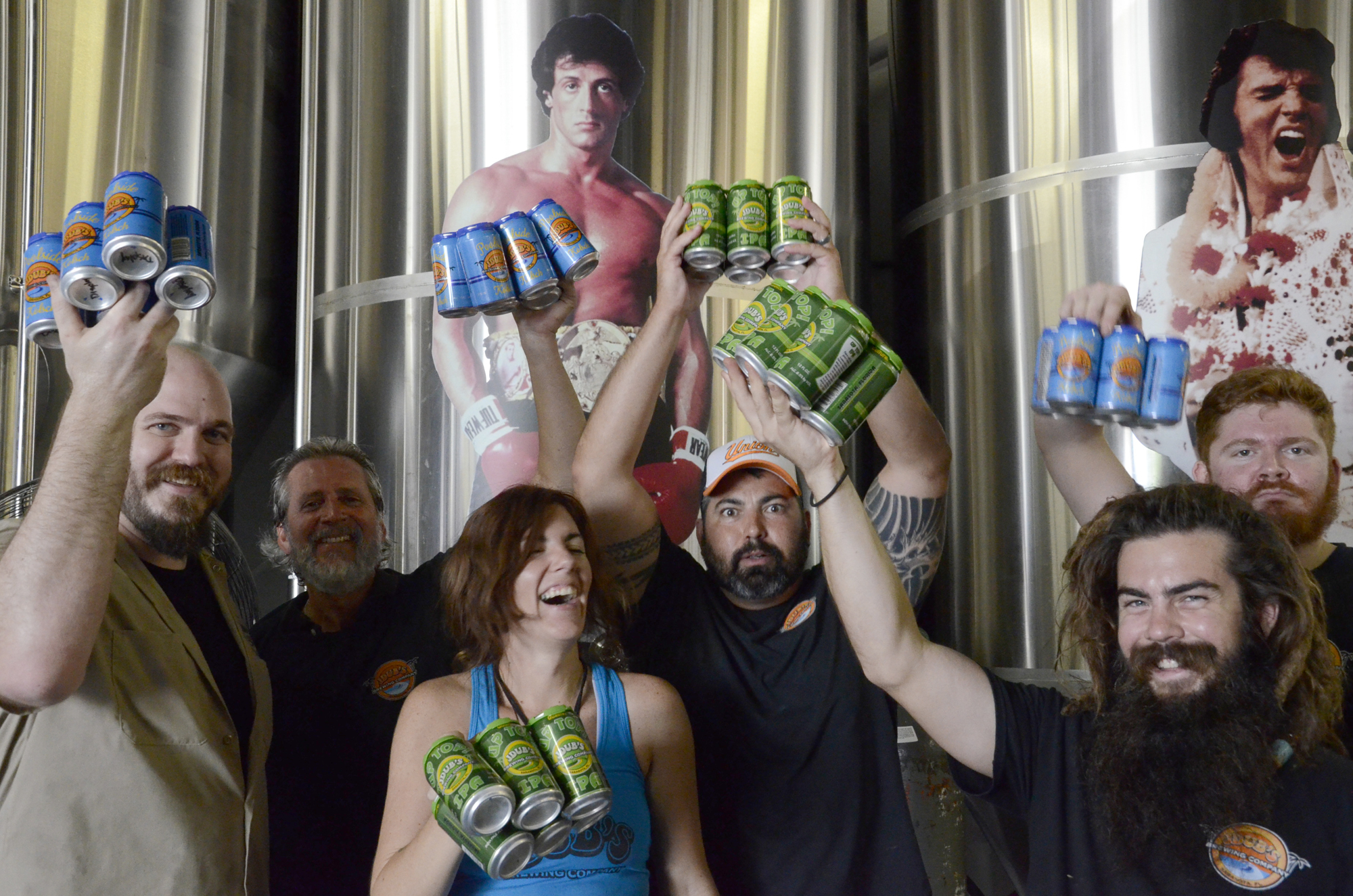 Dave Byrn, Raul Armengol, Jillian Ross, Jeremy Joerger, Evan Ekasala and Chris Lexow show off six-packs of Poolside Kolsch Aleand Up Top! IPA at JDub’s Brewing Co.