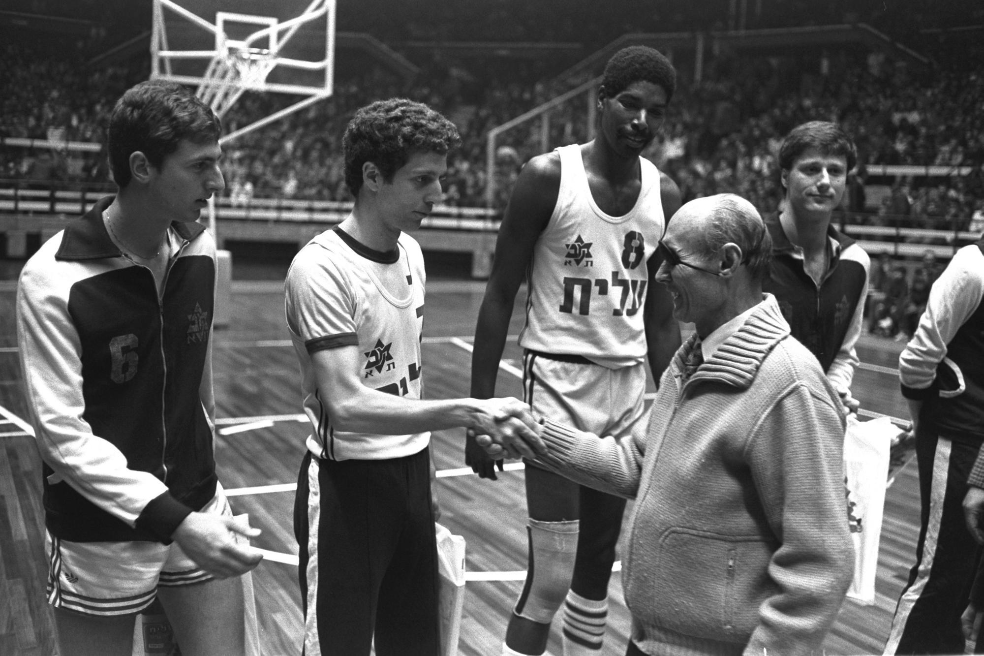 Israel’s Defense Minister, Moshe Dayan, shakes hands with Maccabi Tel Aviv players.