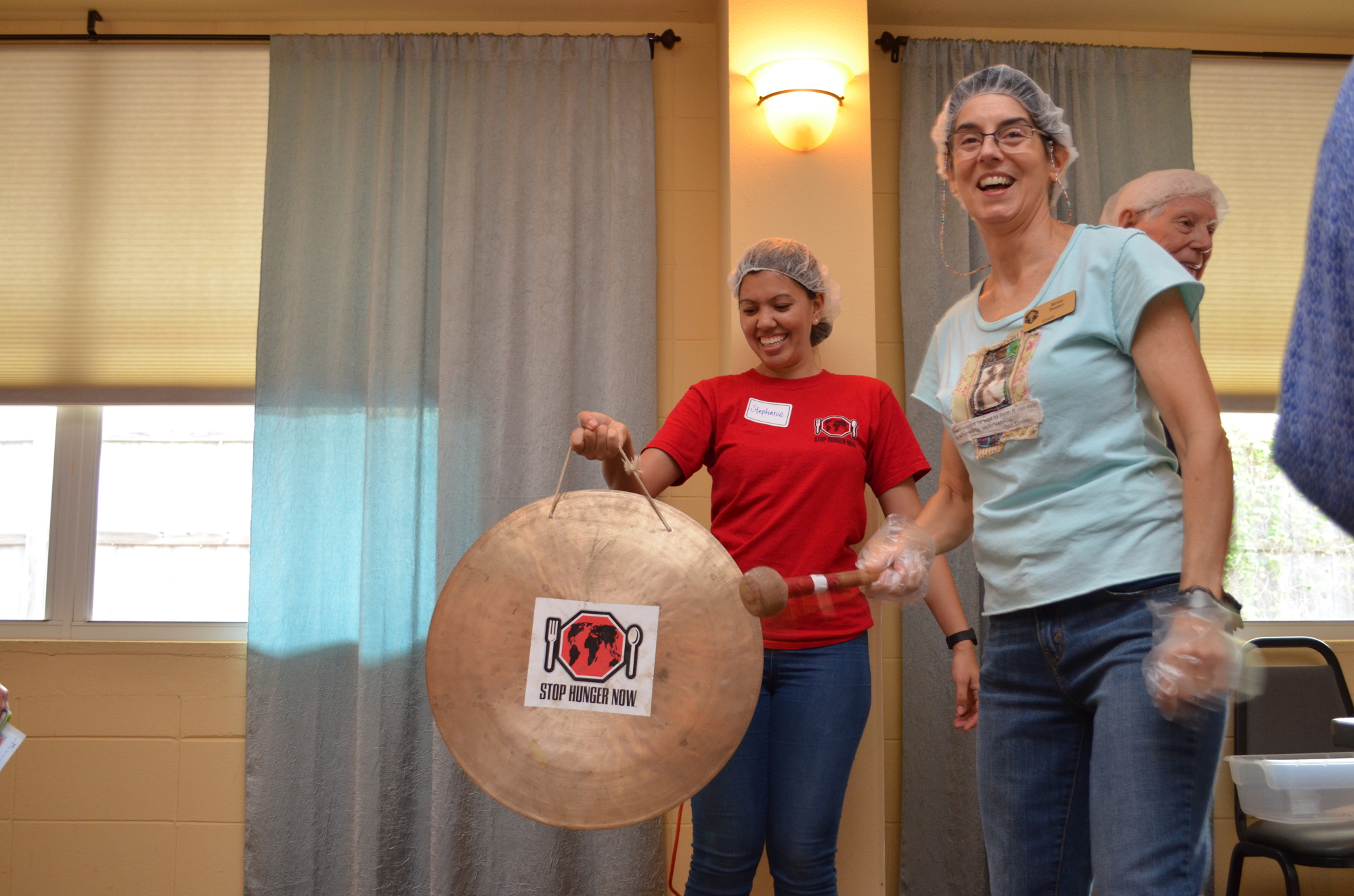 Betsie Danner had the honor of ringing the gong to mark 4,000 meals packed.