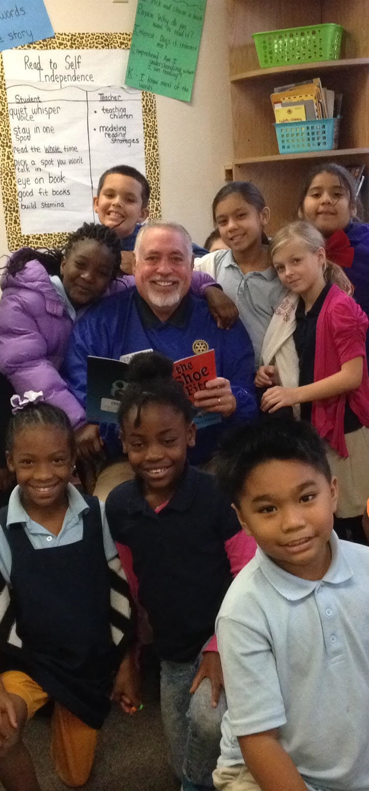 Lakewood Ranch Rotary Club volunteer Ken Kaplan is surrounded by children who just enjoyed one of his reading sessions.