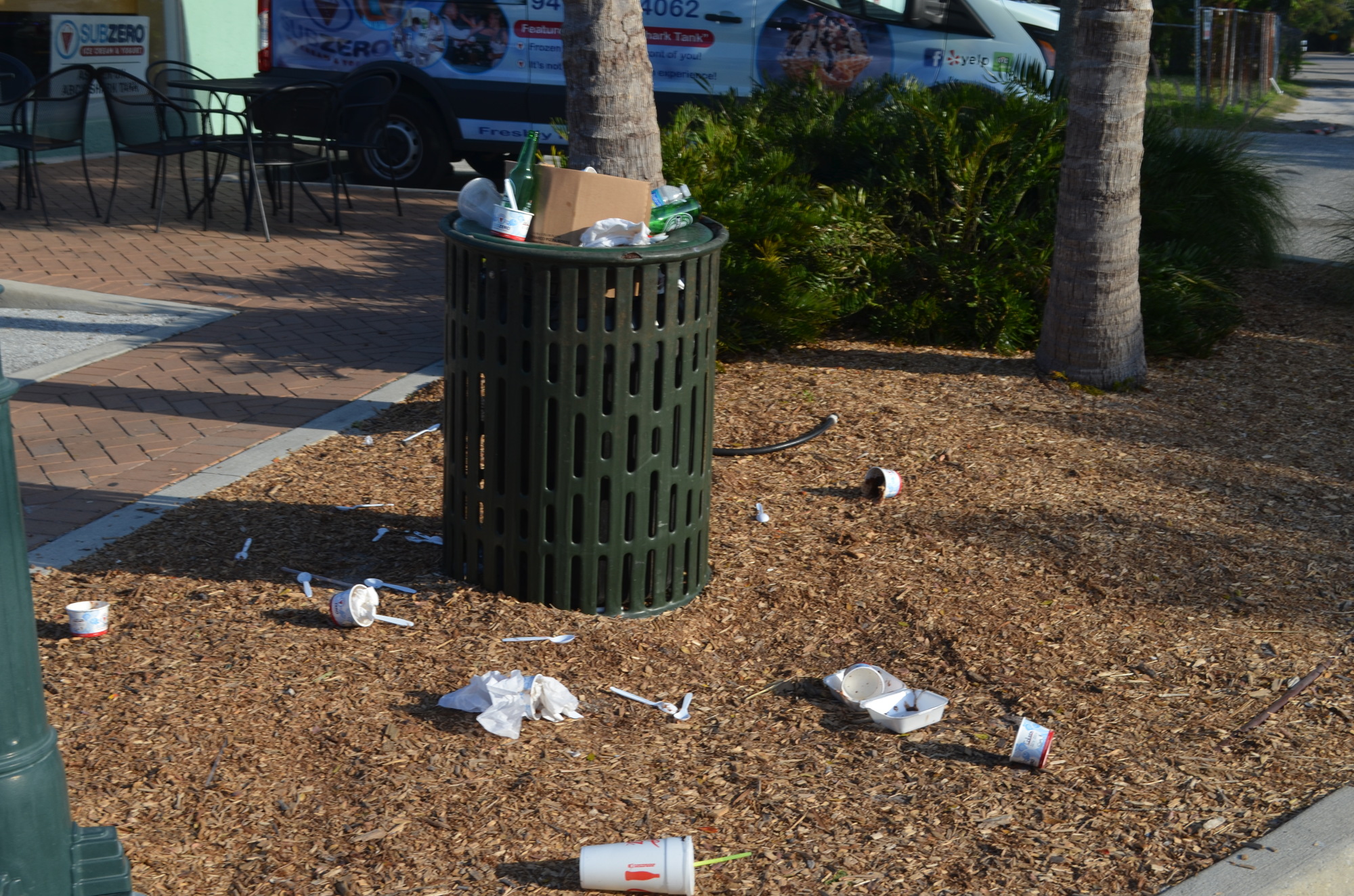 The trash pail outside of Sub Zero Ice Cream & Yogurt overflows with trash before being emptied Wednesday morning.