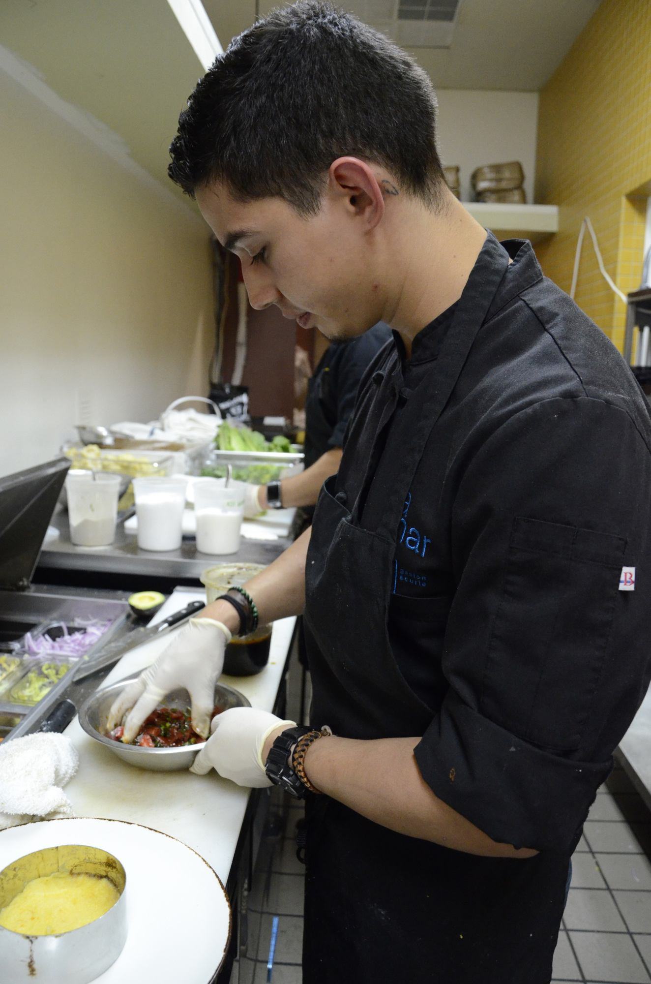 Executive Chef Diego Salazar tosses ahi tuna with a marinade.