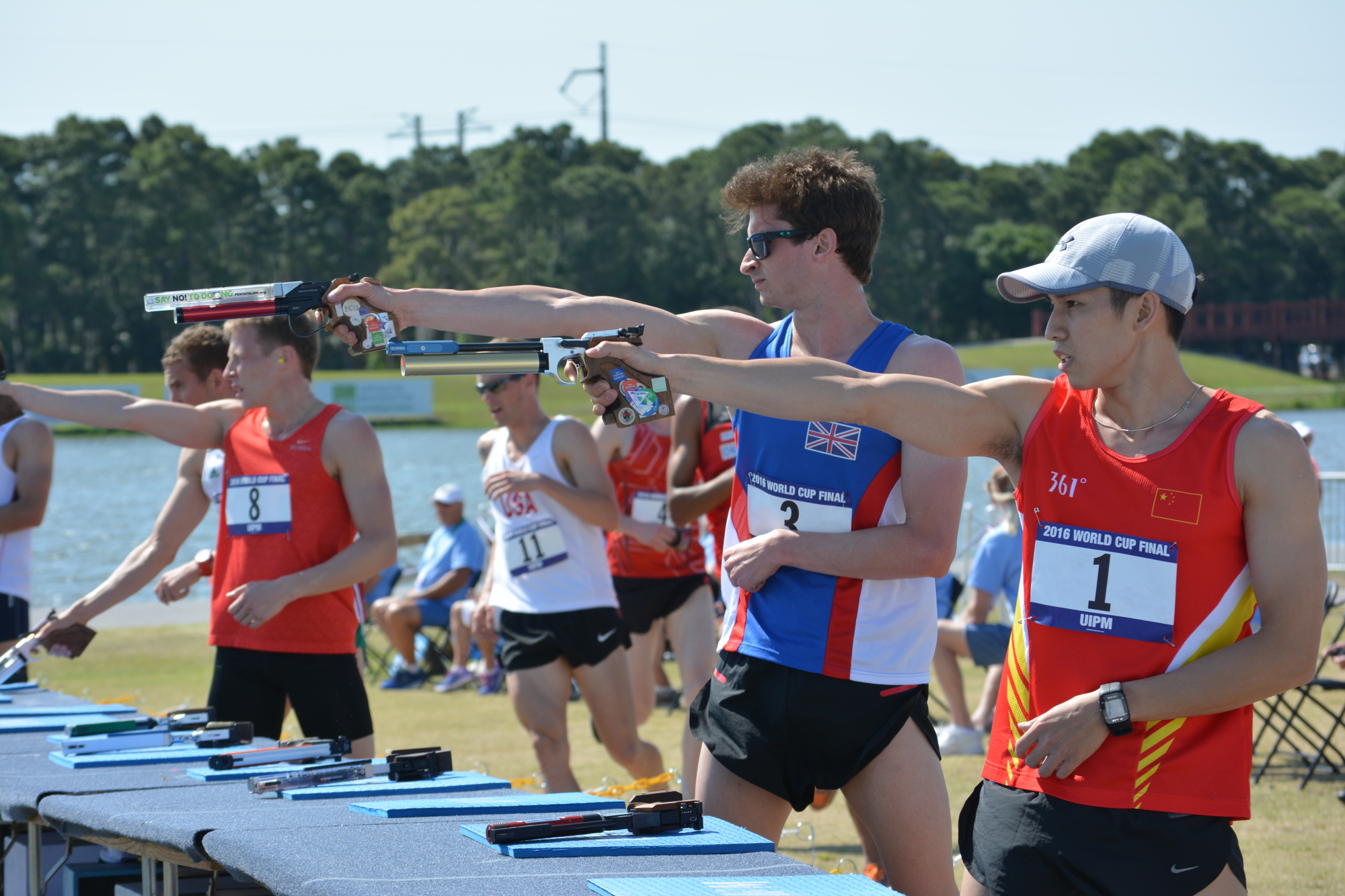 Eventual overall men's champion James Cooke, second from right, grabbed the lead in the pistol shoot/cross-country run from China's Jianli Guo, far right. Guo led the first half of the race but faltered on the shooting range.