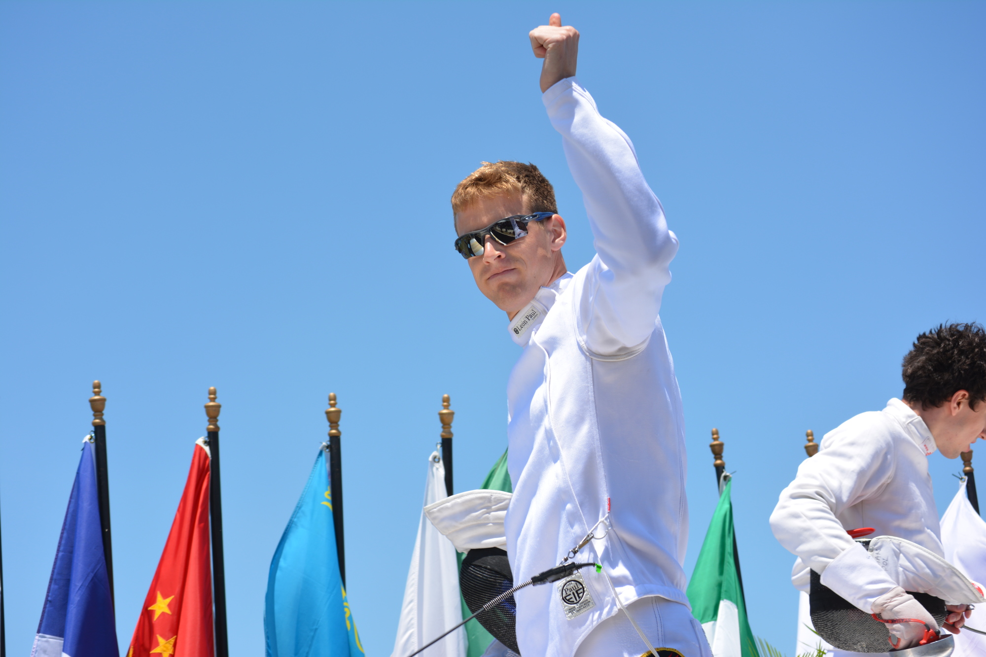 Lucas Schrimsher celebrates a fencing win over China's Jiahao Han.