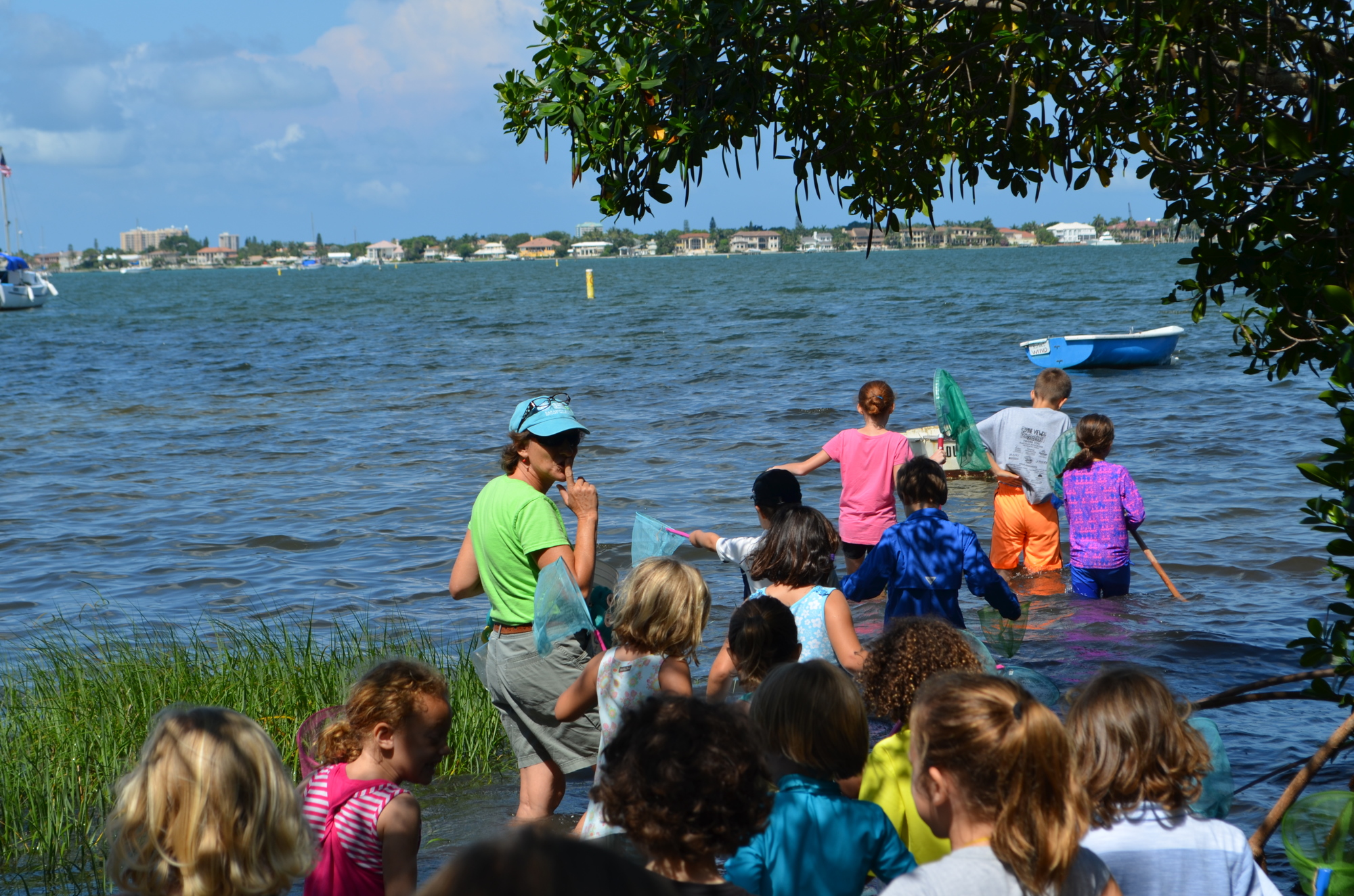 Camp Teacher Karen Willey leads the pack of campers into waist-deep water in Sarasota Bay.