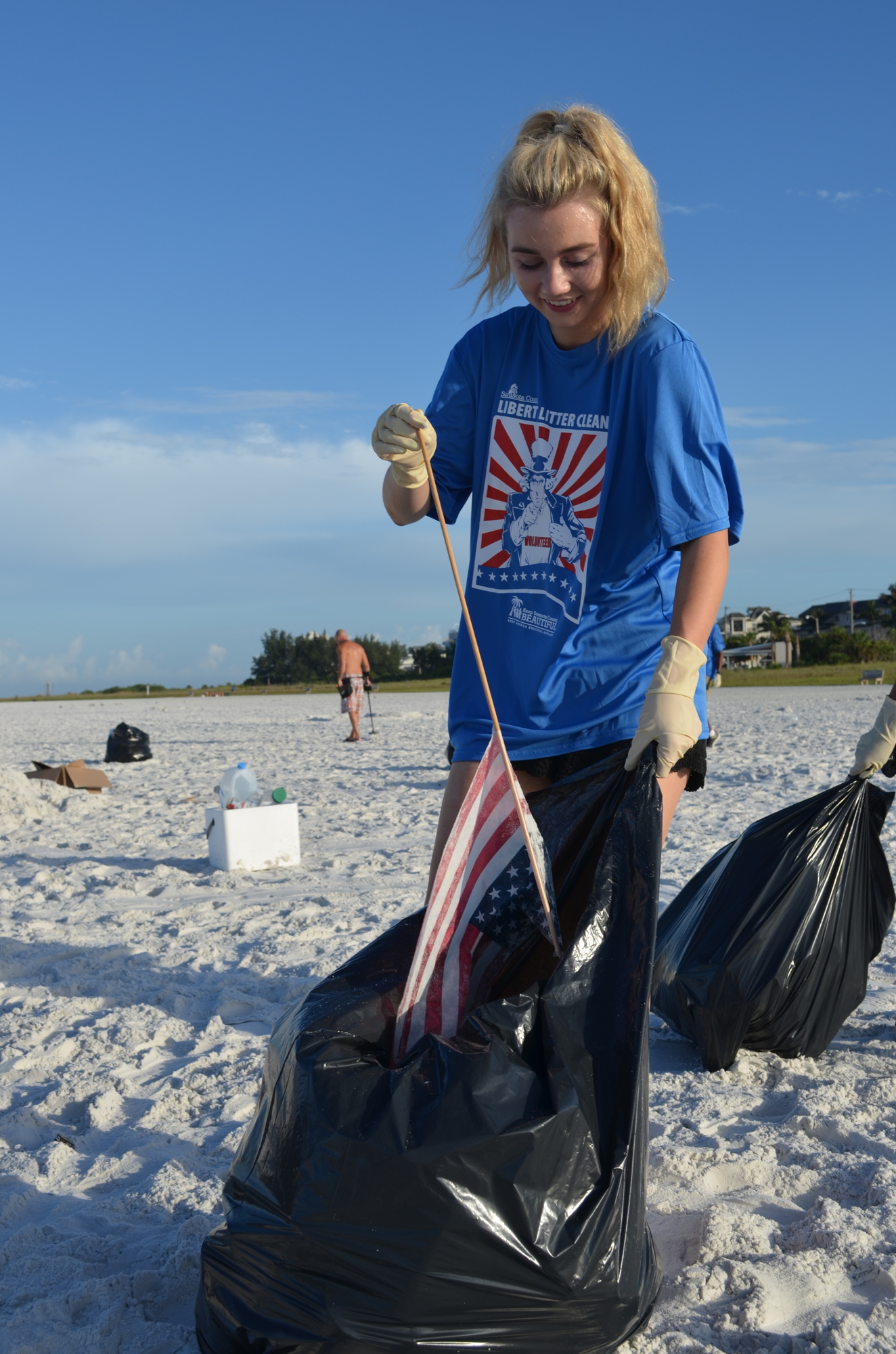 Caroline Middleton of Community Youth Development STAR Leadership  Program plucked a flag that was trampled from the sand.