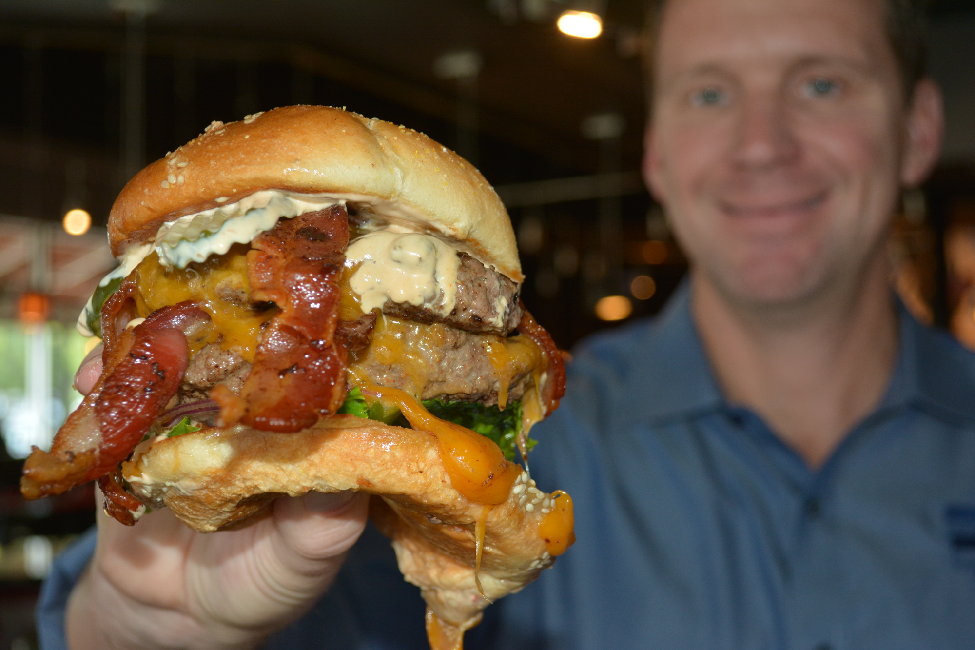 Bill Milner, the vice president of operations at Square 1 Burgers & Bar, shows off a Double Bacon Boomer Sooner.