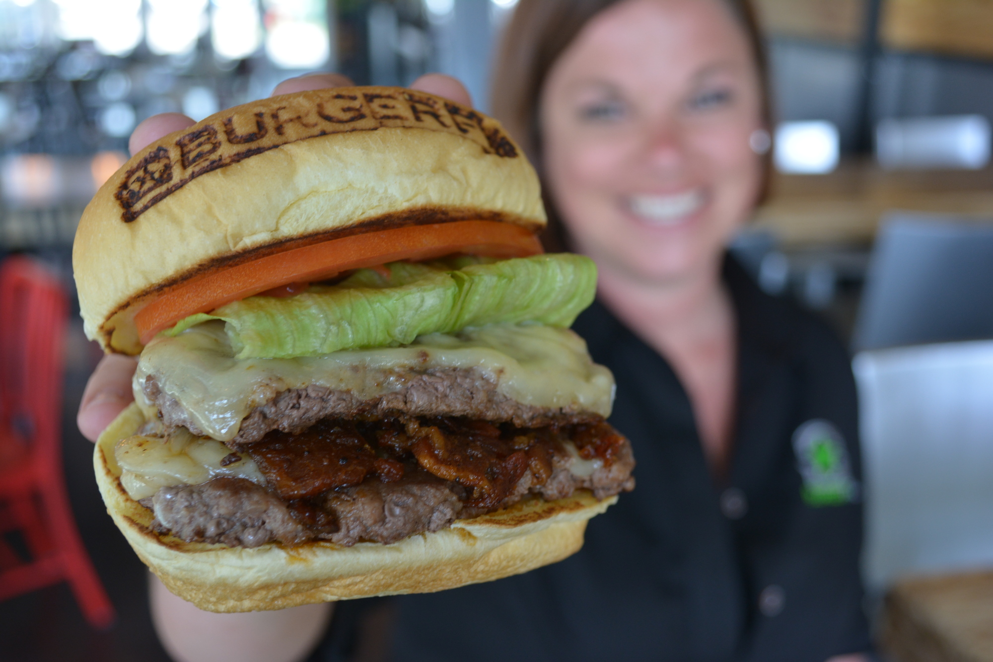 Landyn Crabtree, the general manager of Burger Fi, displays a CEO Burger.