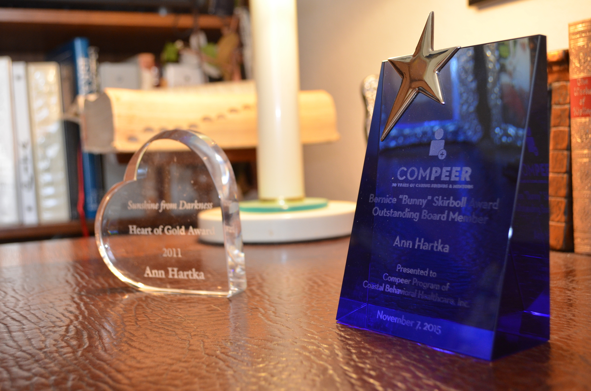 Various awards such as the 2011 Heart of Gold Award from Sunshine from Darkness and the 2015 Bernice “Bunny” Skirboll Award for Outstanding Compeer Board Member, sit on Hartka's desk in her home. Photo by Niki Kottmann.
