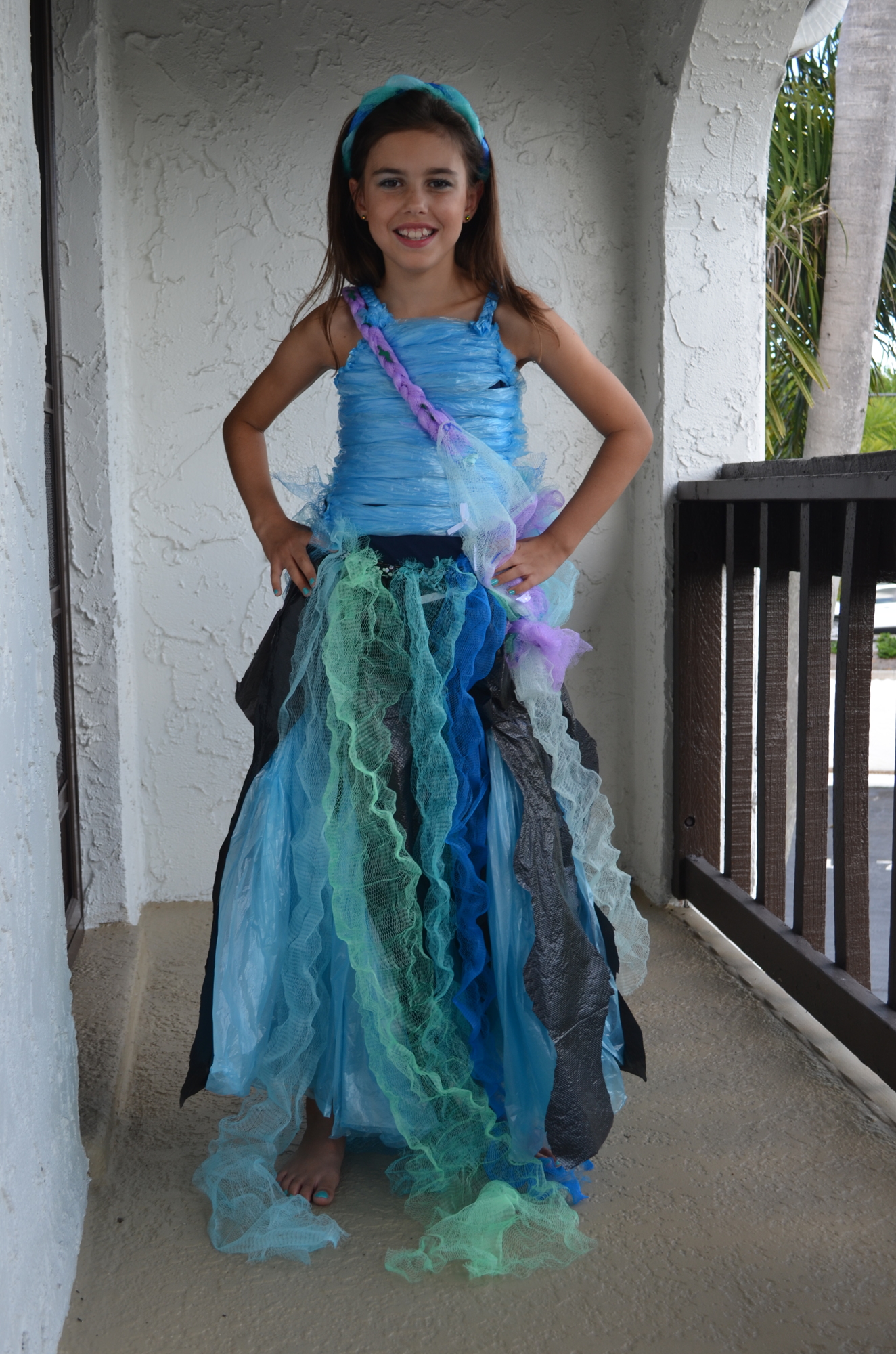Darcey Skelton, 9, models the ocean-themed garbage bag dress that she designed with Tara Torehan and Caroline Yancey. Photo by Niki Kottmann.