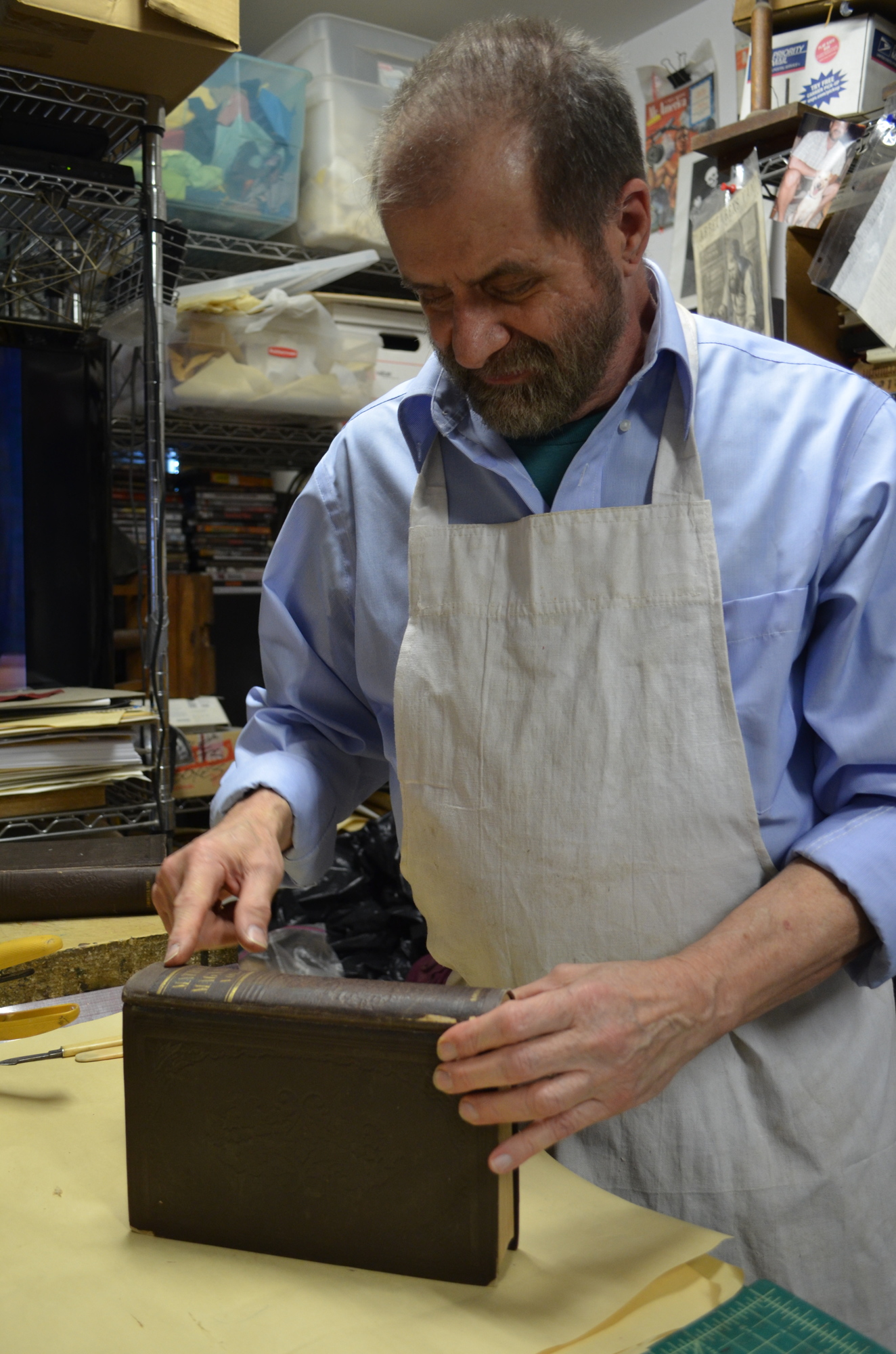 Tapley examines a title he's working to restore that was previously fixed by using tape.