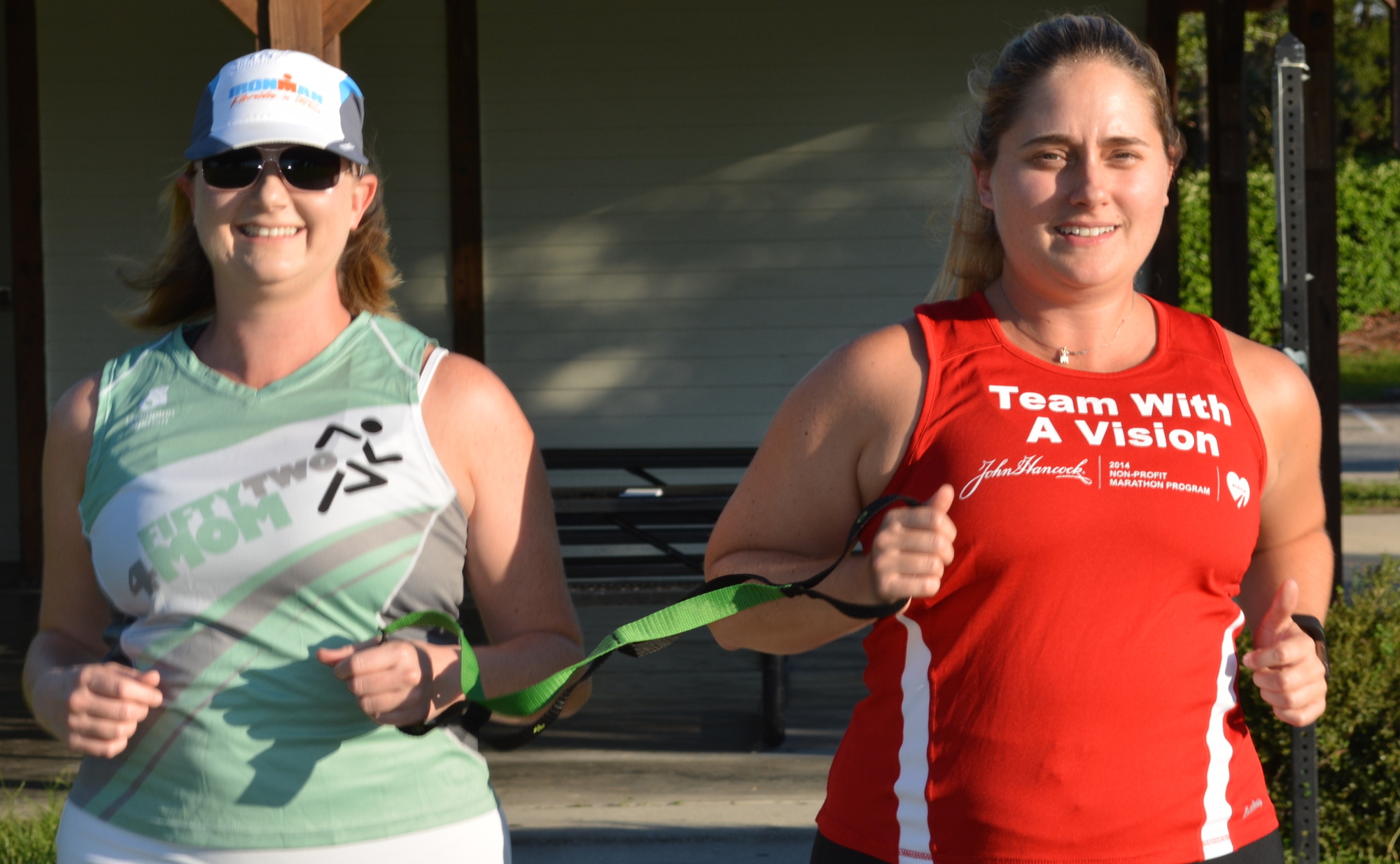 Rebecca Nickens runs alongside her sister, Rachel Weeks, with a strap connecting them during races.
