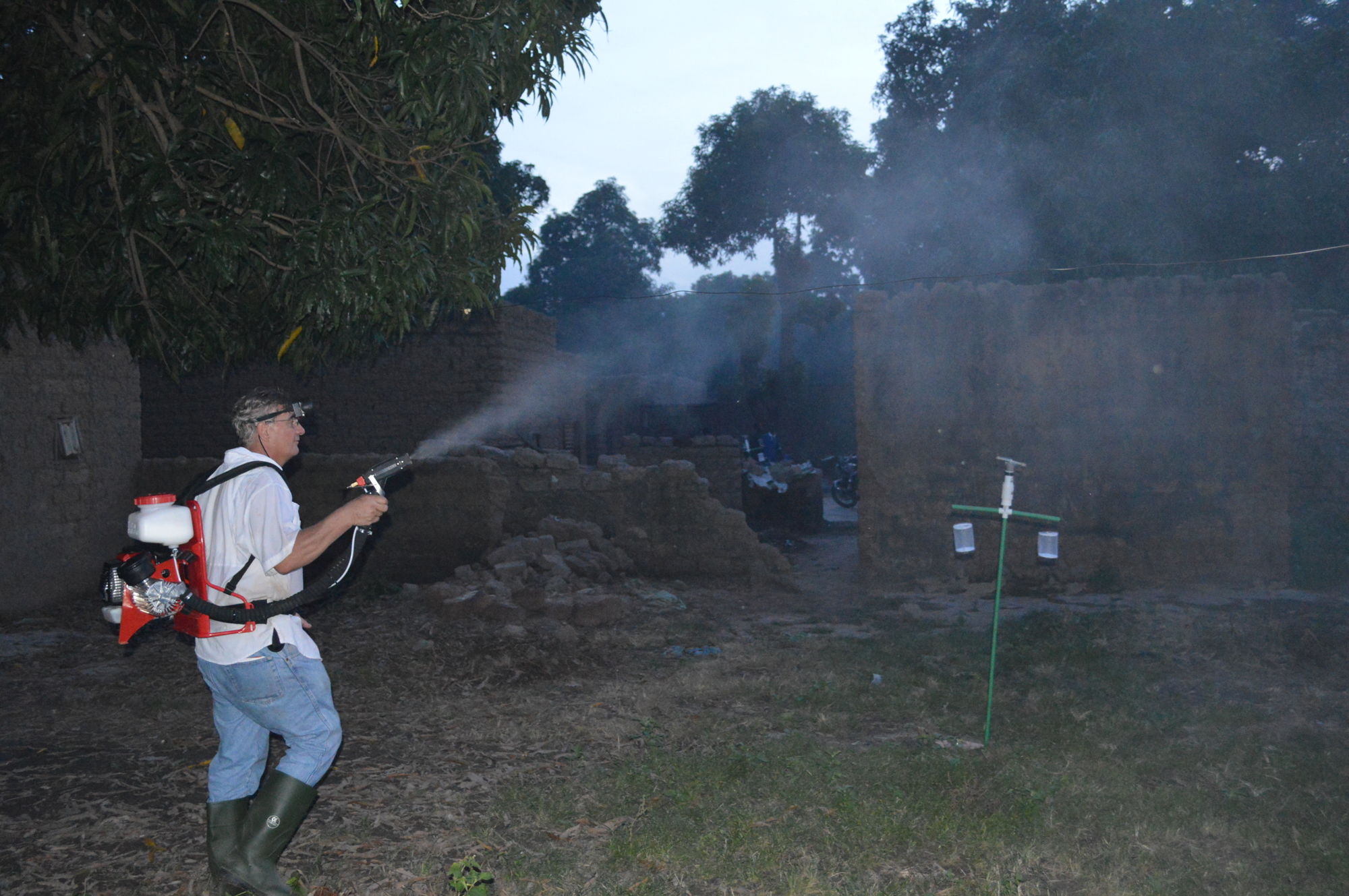 Mill Creek's Mark Latham sprays a swarm of mosquitoes with a motorized backpack sprayer in a small village in Burkina Faso.