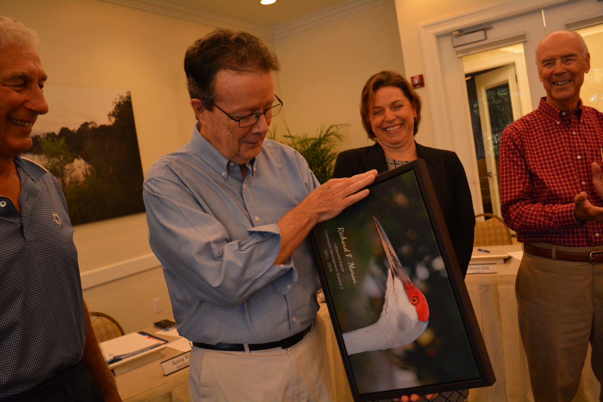 CDD 2 Supervisor Dick Moran accepts a gift — one of his photographs hanging at Lakewood Ranch Town Hall — from Town Hall Executive Director Anne Ross.
