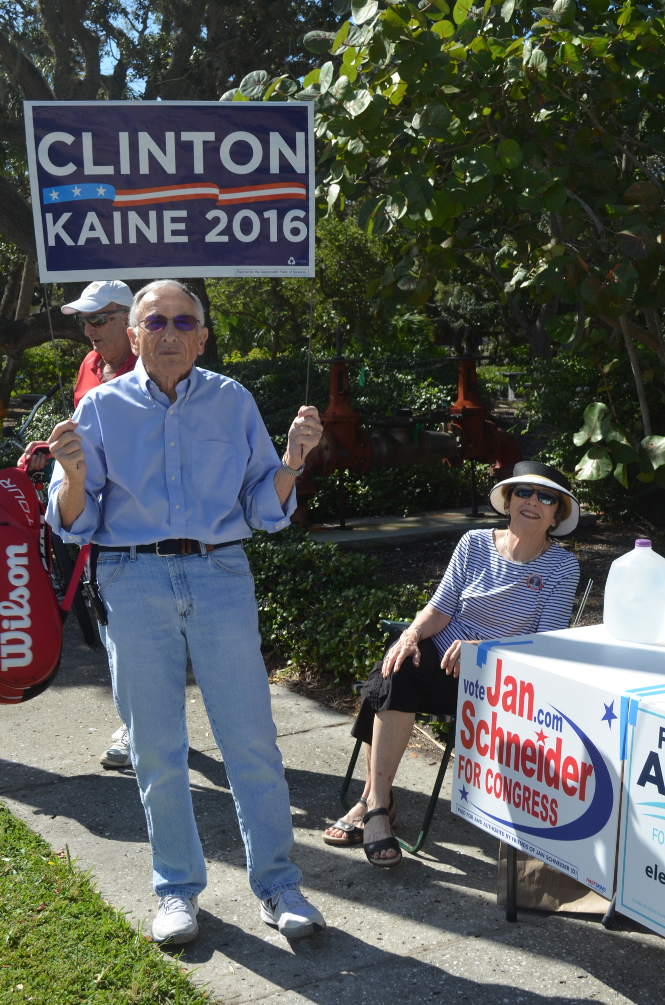 Democrats Joel Mangel and his wife, Carolyn Mangel, wave the flag Tuesday at Precinct 201 in Town Hall. Terry O'Connor