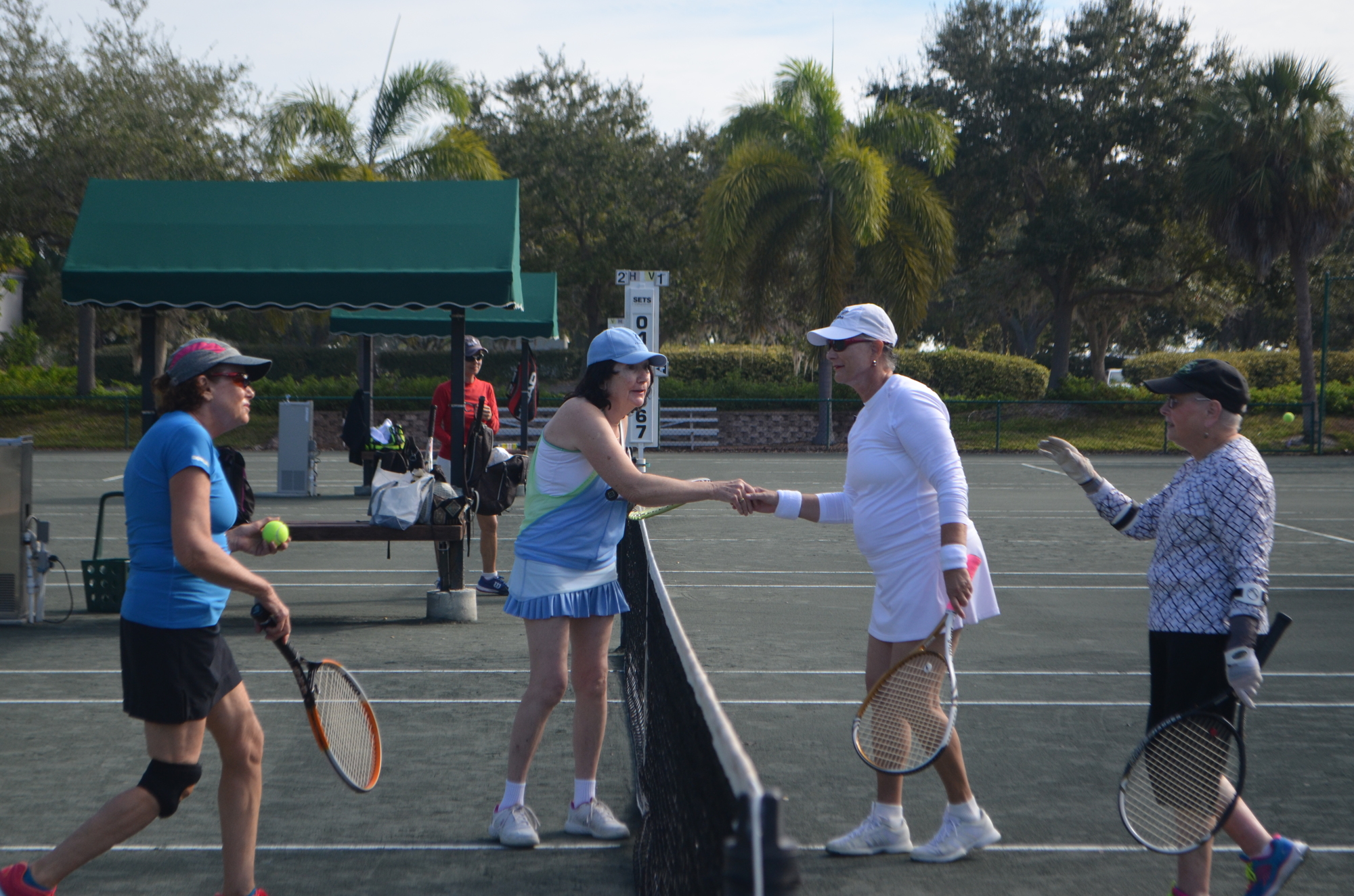 Karen Gary, Gisele  Virgien, Jean Gramaglia, Sally Steele go to shake hands after a tennis match. 