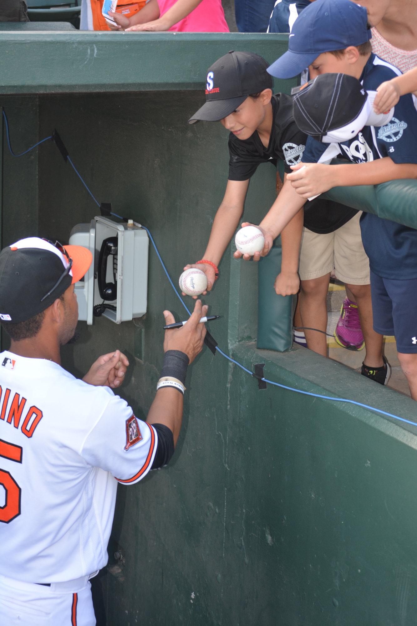 Baltimore Orioles infielder Robert Andino signs autographs for young fans.