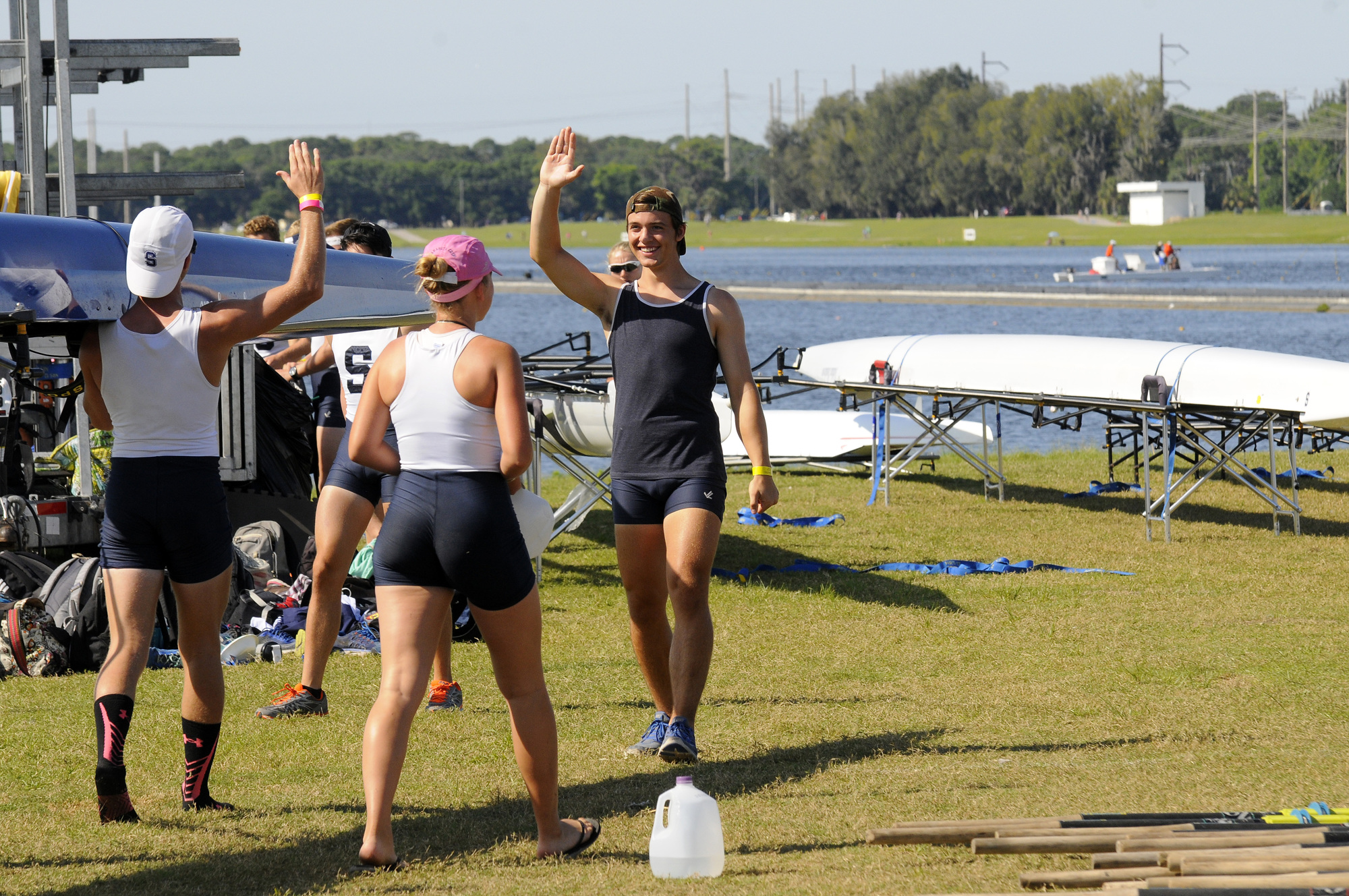 Trey Whitten and Lydia Bremer walk toward the high-fiving Jamie Velez after the Men's Lightweight 4+ race at the SE Championships on May 15. File photo