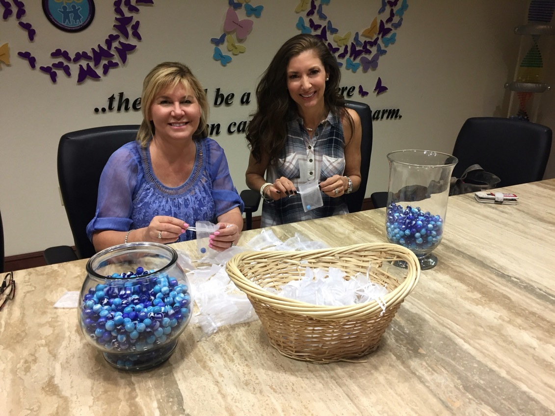 Tammy Karp and Donna Koffman prepare for Blue Ties & Butterflies at Child Protection Center on March 22. Photo courtesy of Mya Widmyer