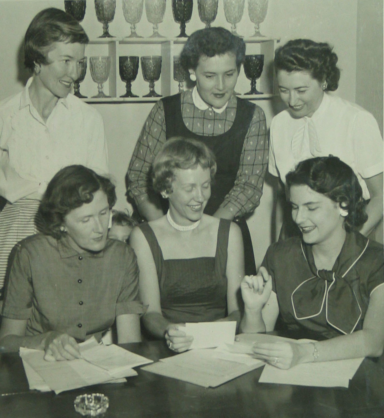 Newly elected officers of the Junior Welfare League (standing) Ethel Kirchner, Dorothy Heritage, MaryAnn Hoyt (seated) Anita O’Connor, Suzanne Bissell and Bitsy Robertson review the just-adopted bylaws on April 2, 1957.
