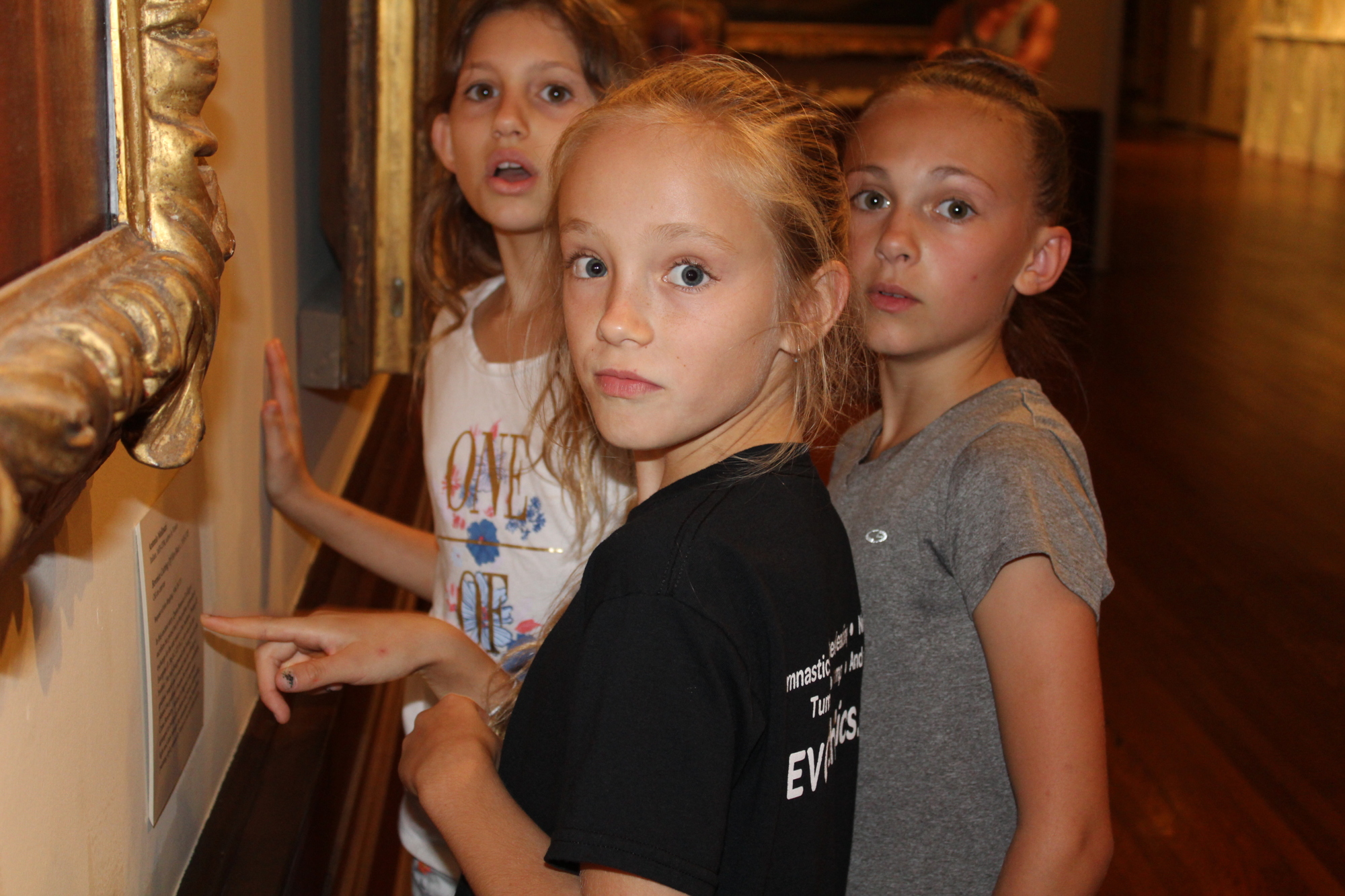 Front to back. Braden River Elementary School fourth graders Rose Reece, Nadia Benko and Cora Augustine examine a painting in the Ringling Museum of Art.