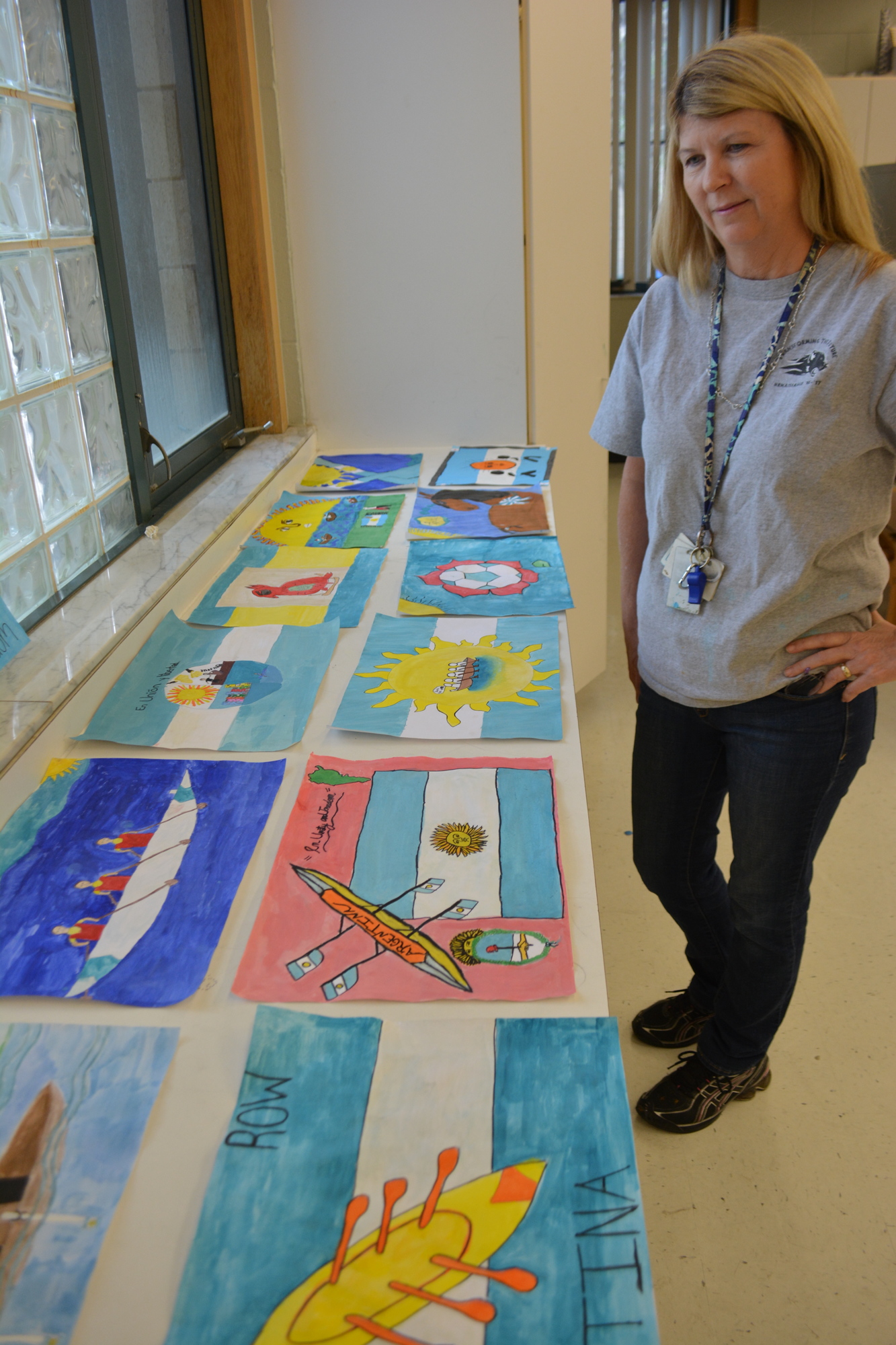 Art teacher Heidi Enneking looks over her sixth-grade students' work.