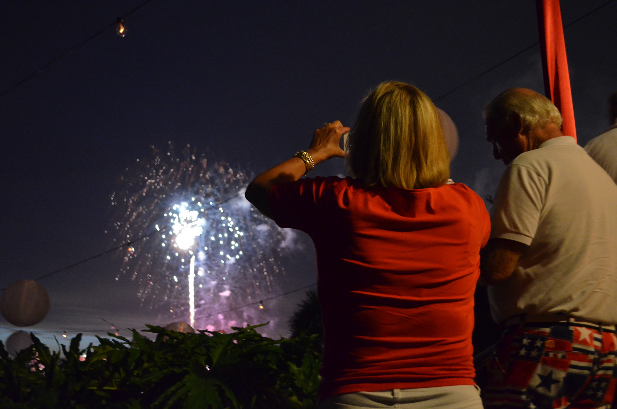 Lisa Carter captures the fireworks over Sarasota Bay from the terrace of the great room at Marie Selby Botanical Gardens on July 4, 2016. Photo by Amanda Morales