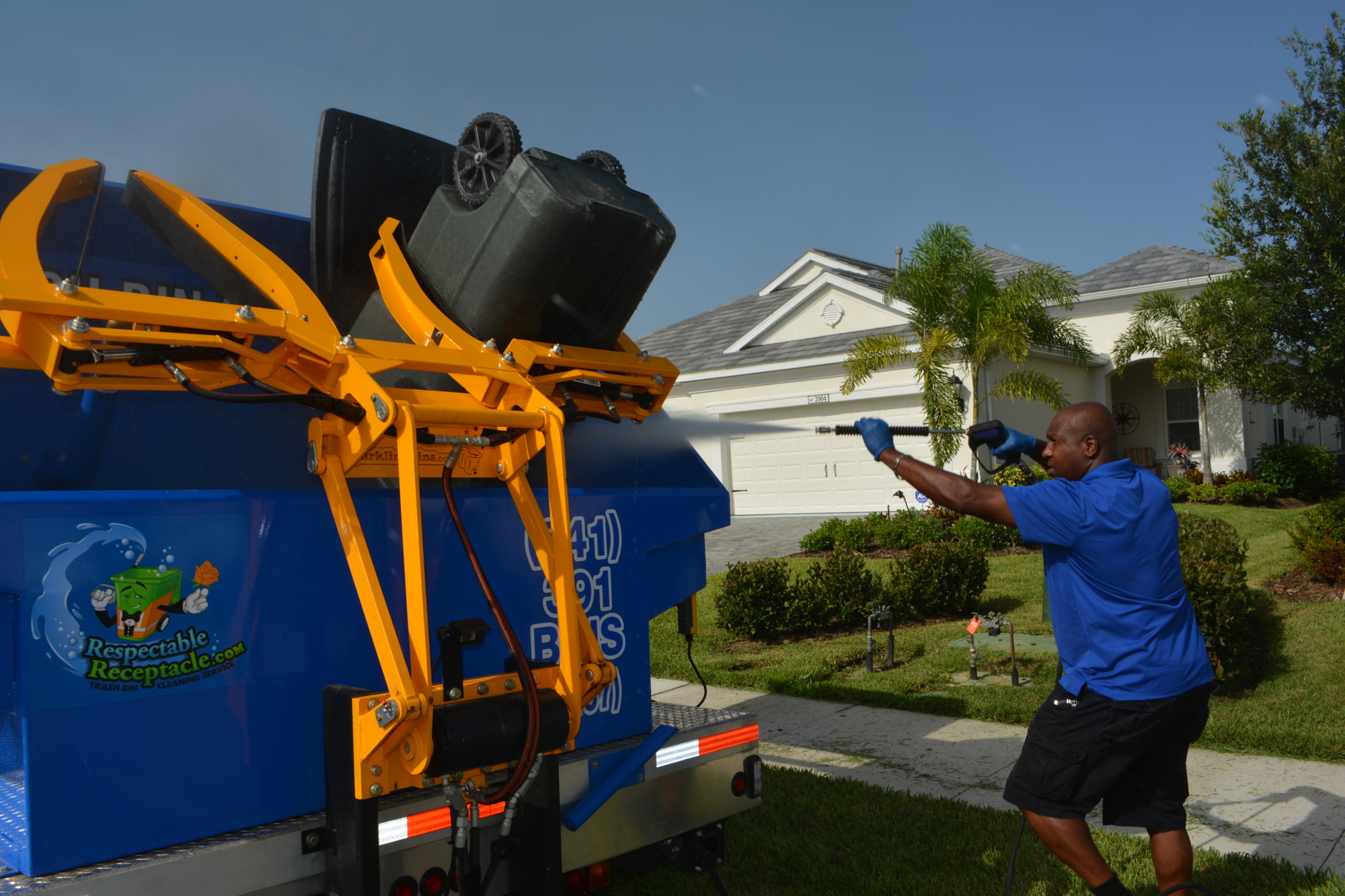 James Lilly washes a trash bin in Lakewood Ranch with his new specialty Respectable Receptacle truck.