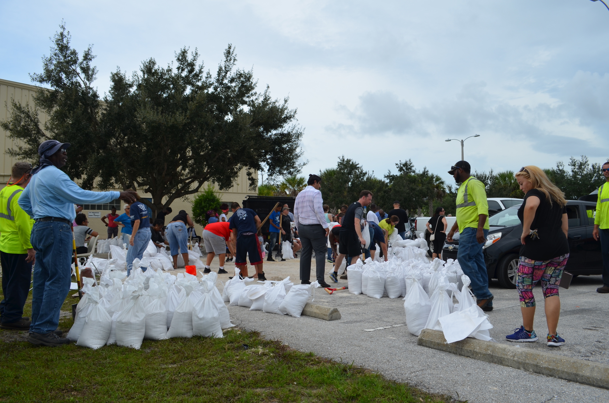 Residents pick up sandbags Tuesday morning at Newtown Estates Park. The county-provided goods are in short supply ahead of the storm.