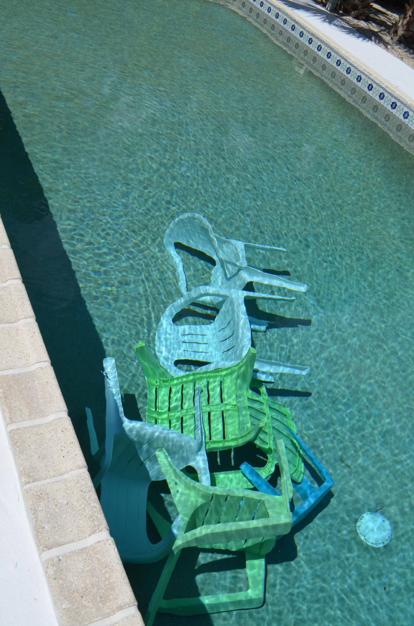 Zanne Gordon stores her plastic lawn furniture at the bottom of her pool in preparation for the storm.
