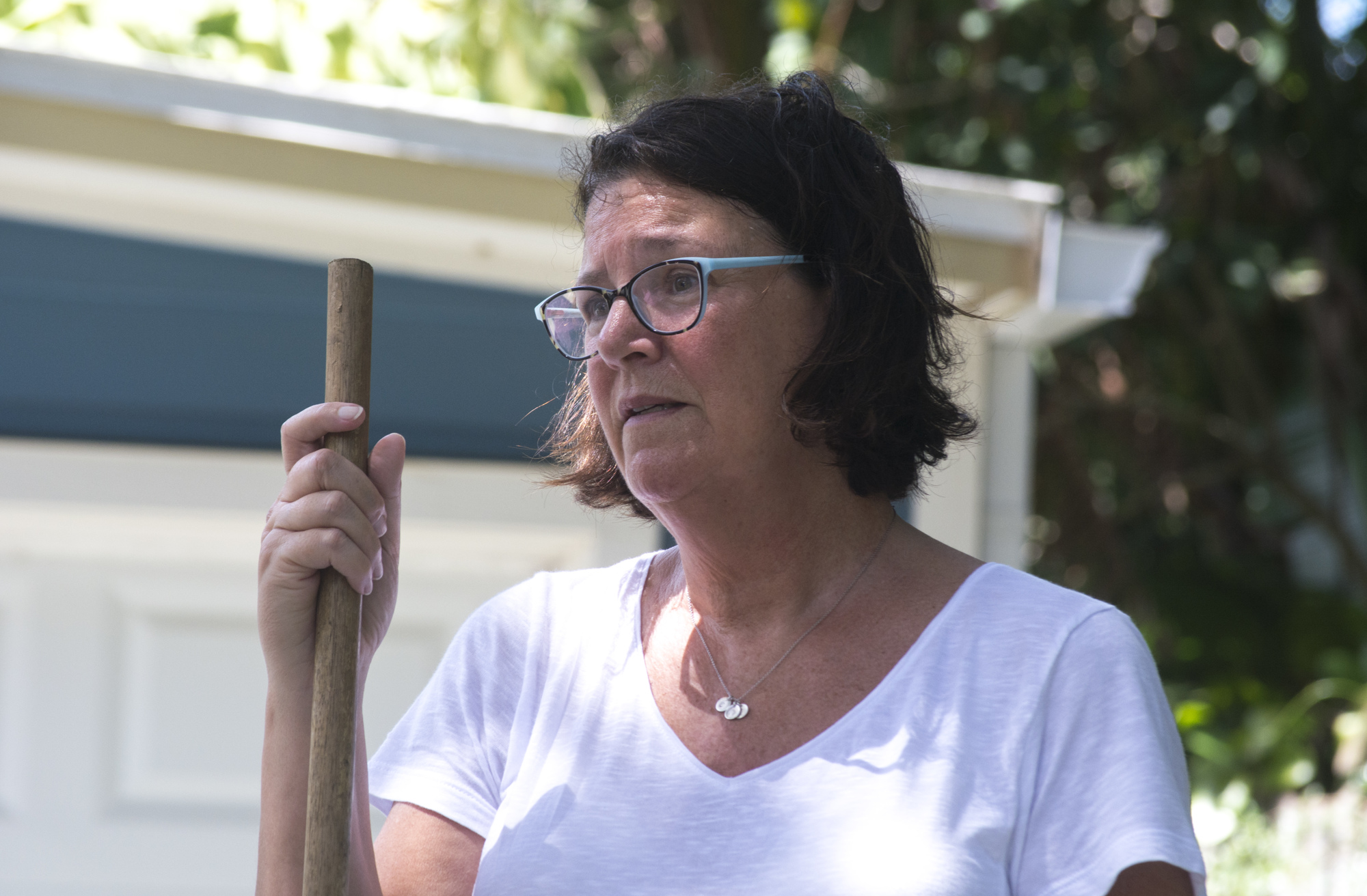 Lisa Dodds rakes fallen leaves and branches from her driveway of her north Siesta Key home.
