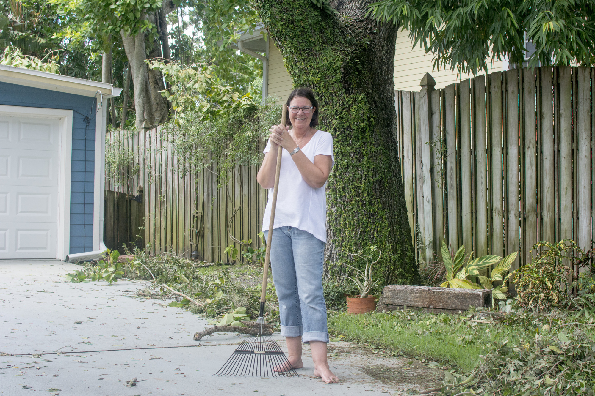 Lisa Dodds rakes debris in her yard after Hurricane Irma.