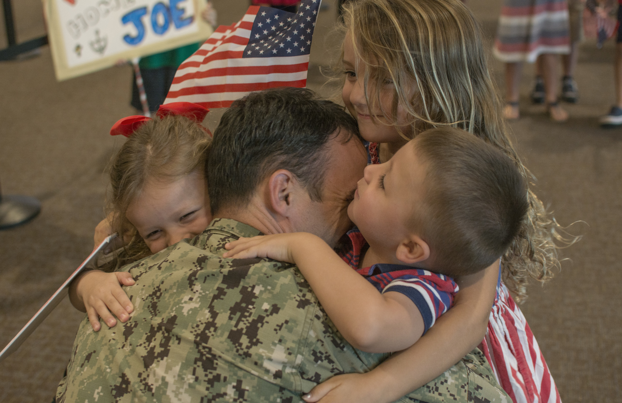 Annabelle, Lizzy and James Hembree hug Commander Joe Hembree  in Sarasota-Bradenton International Airport on Sept. 29.