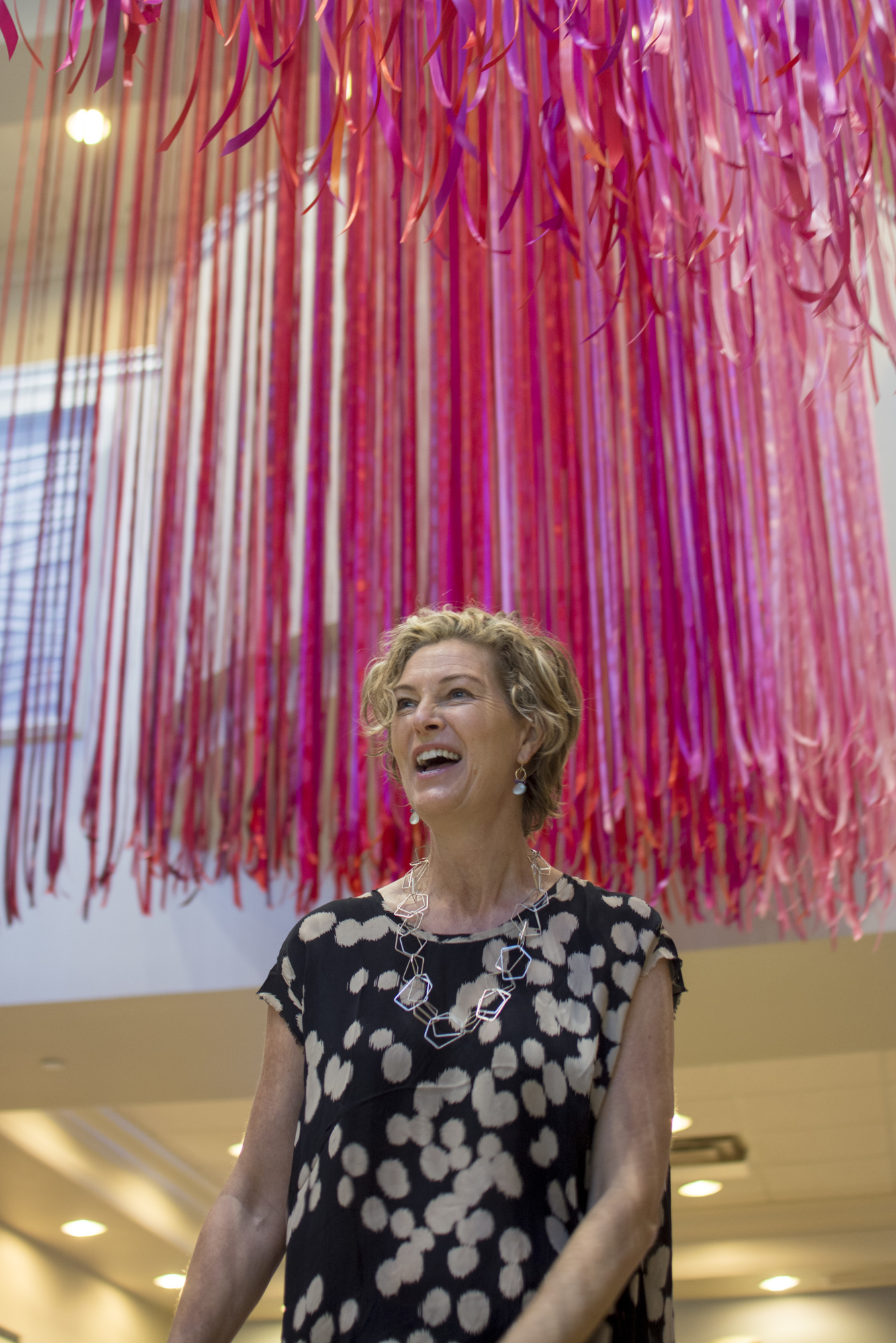 Anne Patterson stands under her latest piece entitled 
