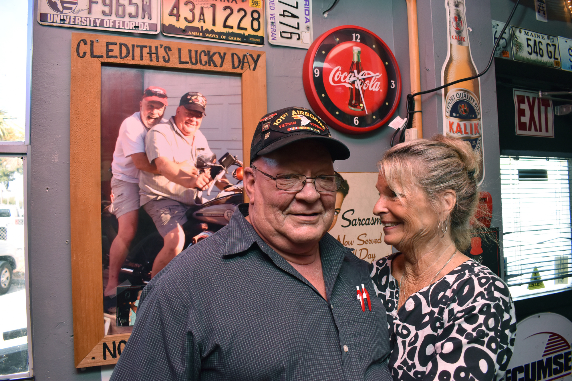 Bartender Cledith Coleman poses with regular Susie Tanner in front of Coleman's honored spot on the wall. Photo by Niki Kottmann